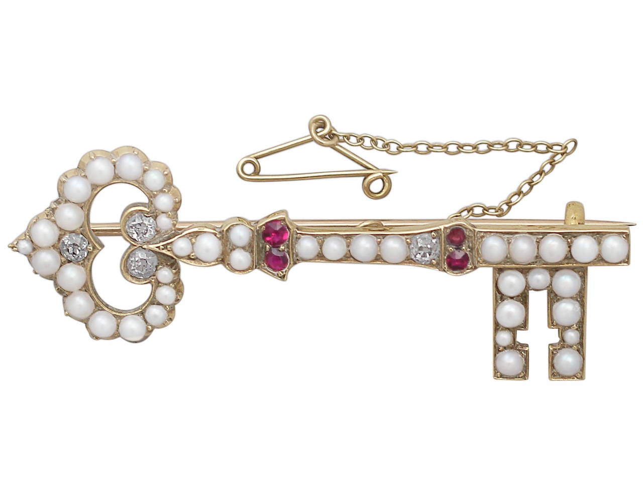 A fine antique Victorian 0.32 ct diamond, seed pearl and ruby, 18 karat yellow gold key brooch; part of our diverse antique jewelry and estate jewelry collections

This fine antique Victorian brooch has been crafted in 18k yellow gold, in the form