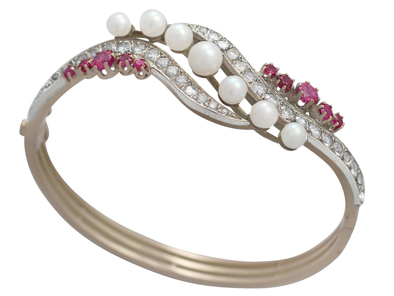 A stunning, fine and impressive pearl, ruby and diamond bangle in 18 karat yellow gold; part of our antique jewelry and estate jewelry collections

This stunning antique bangle has been crafted in 18k yellow gold.

The anterior portion of this