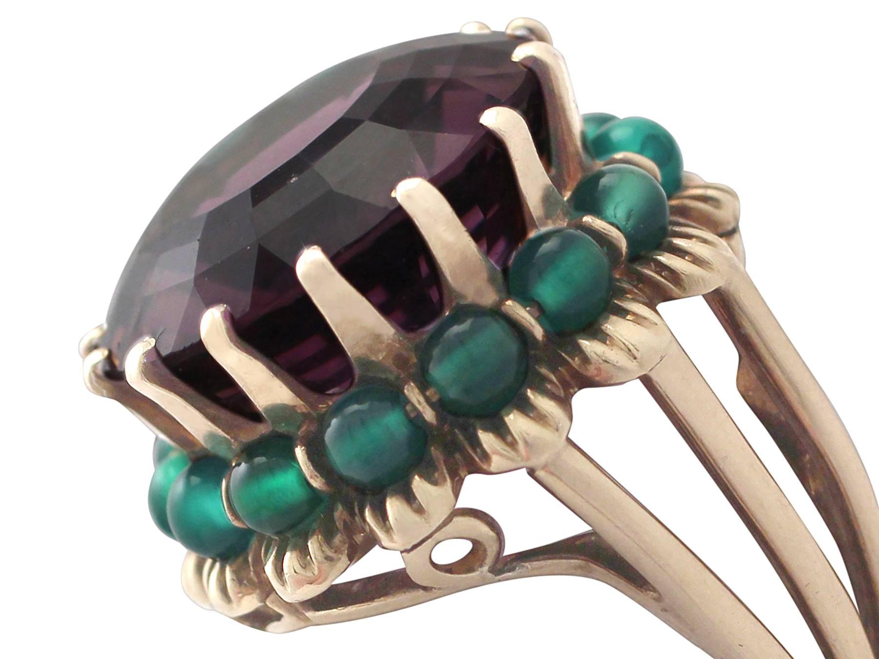A fine and impressive 19.48 carat amethyst and green paste, 14 karat yellow gold dress ring in the Art Deco style; part of our diverse vintage jewelry and estate jewelry collections

This fine and impressive vintage amethyst cocktail ring has been
