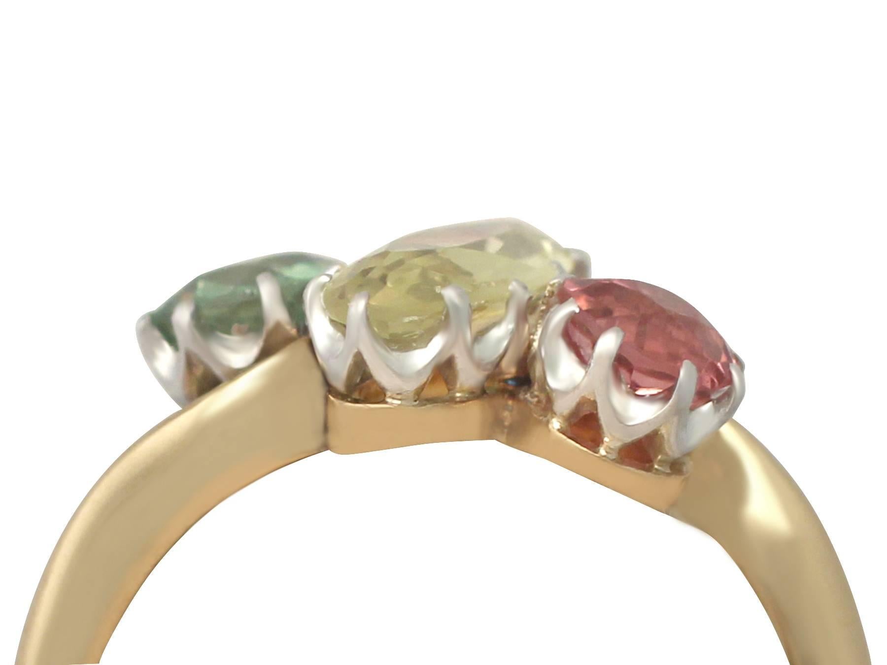 A stunning antique 1.40 carat yellow sapphire and 0.98 carat demantoid garnet, 0.57 carat pink tourmaline and 18k yellow gold trilogy twist ring with a platinum setting; part of our diverse antique jewellery and estate jewelry collections

This