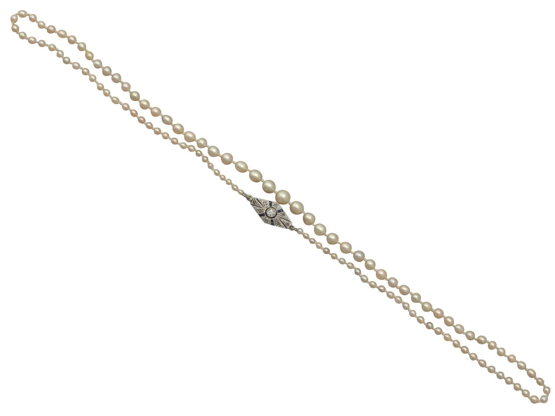 This fine and impressive antique pearl necklace with diamond clasp has been crafted in 18 ct yellow gold with an 18 ct white gold setting.

This impressive single strand pearl necklace consists of one hundred and eleven individually knotted natural