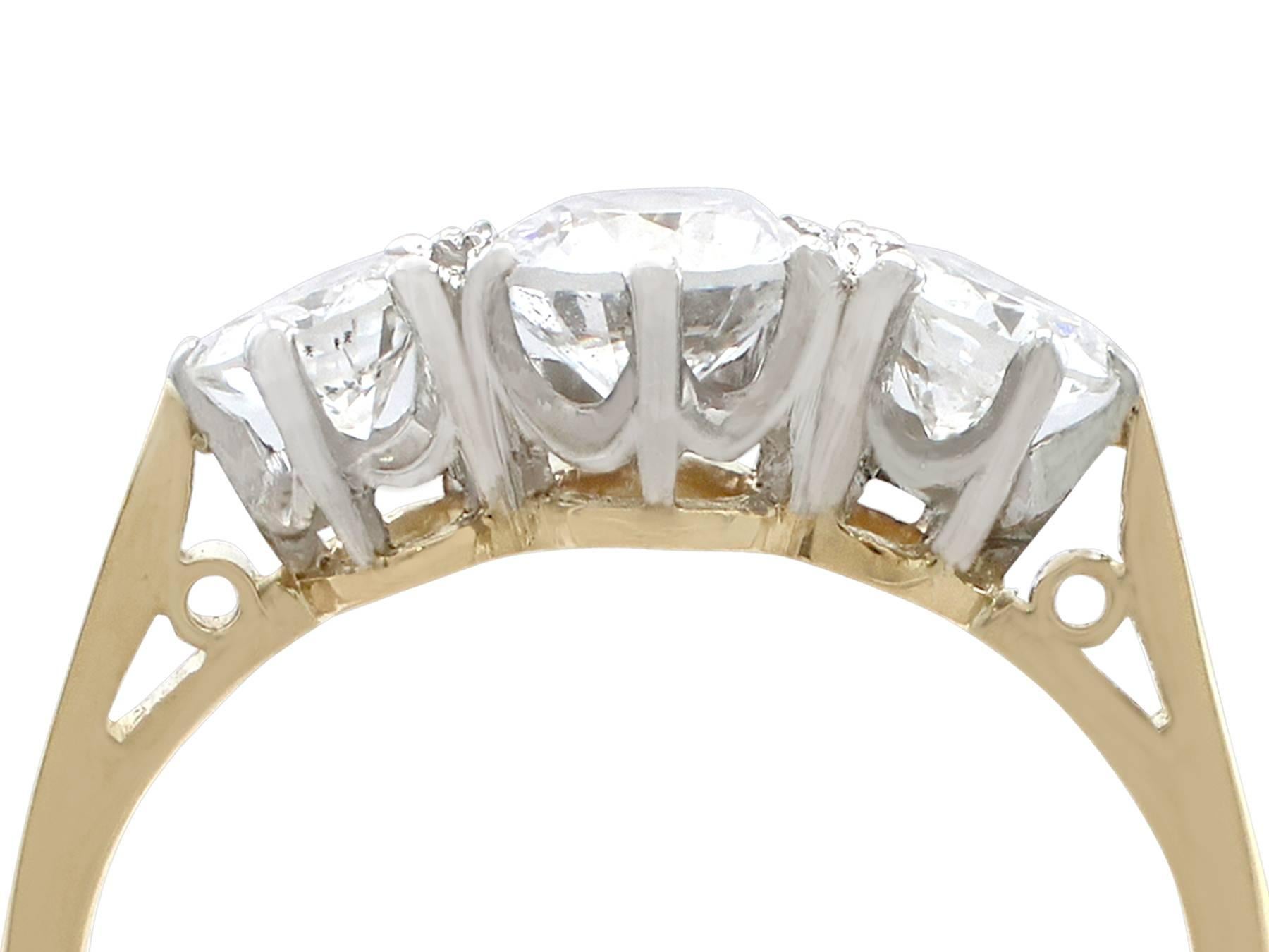 A fine and impressive vintage 1.27 carat diamond and 18 karat yellow gold, platinum set three stone/trilogy ring; part of our vintage jewelry and estate jewelry collections

This fine vintage three stone engagement ring has been crafted in 18k