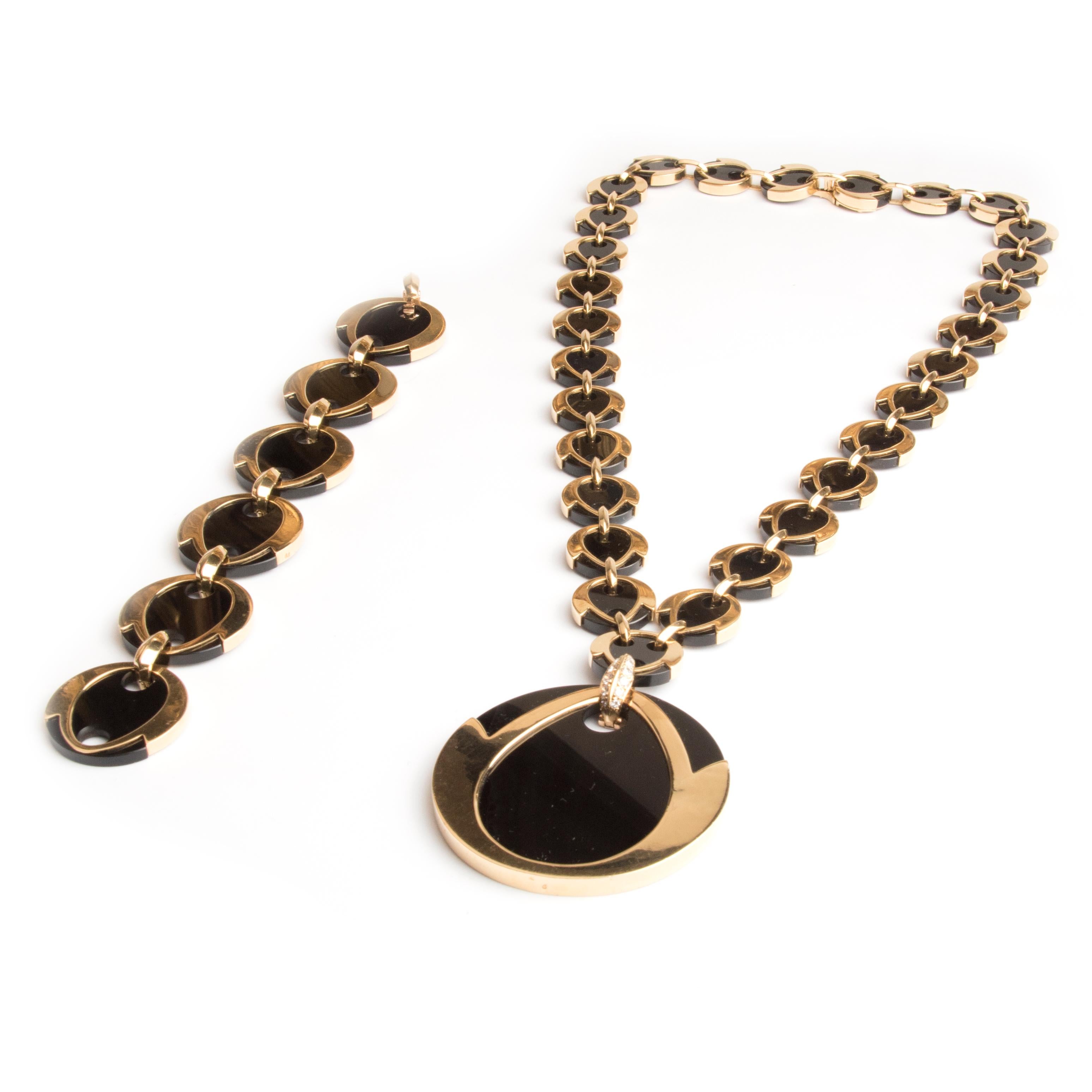 Stylish bracelet and necklace parure by Boucheron Paris, the necklace designed as linked circular 18kt yellow gold discs set with onyx plaques, with a large detachable pendant of the same design attached by a hook set with diamonds. The bracelet