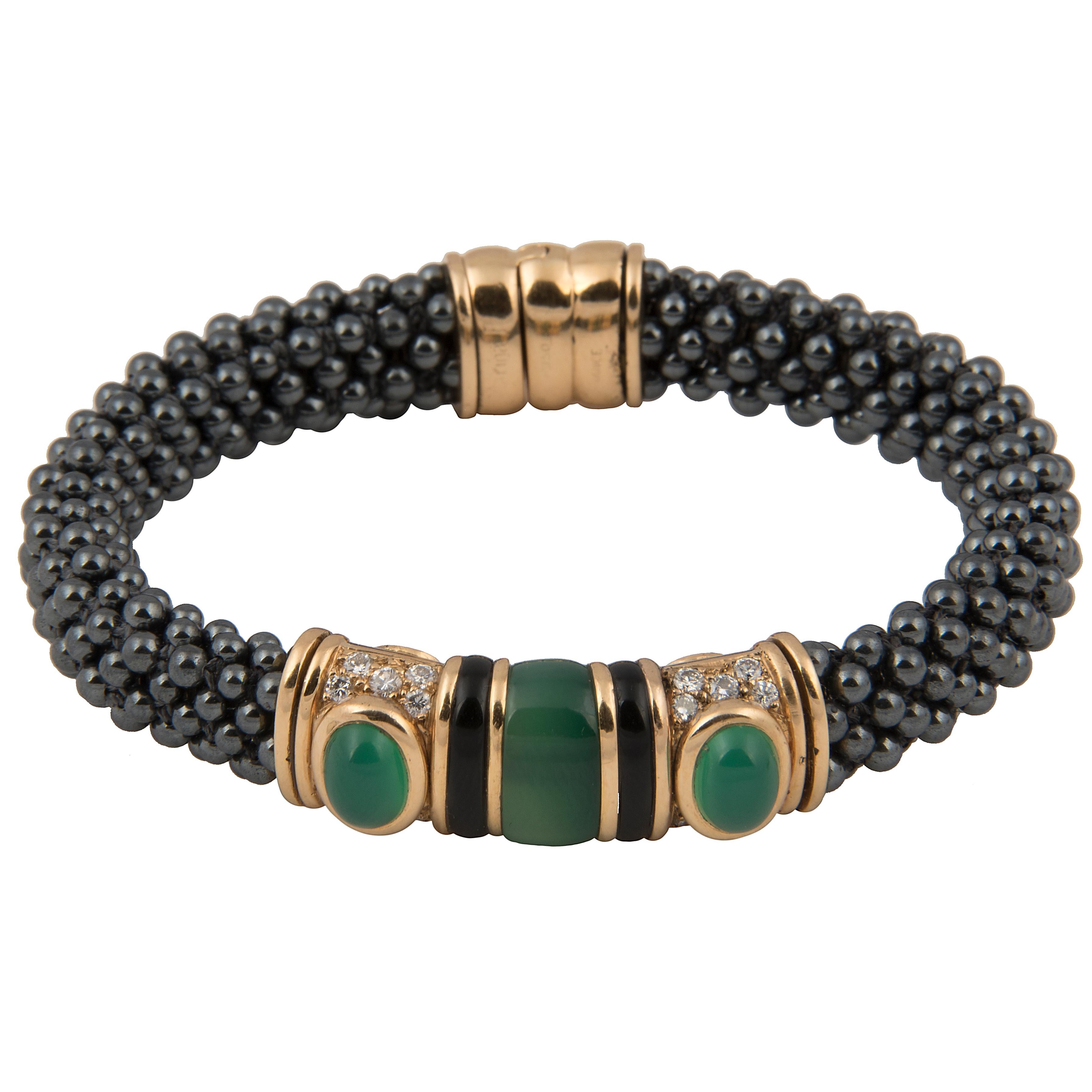 Bangle bracelet designed by Marina B (Bulgari). The band in braided Hematite on a stainless-steel spring, with an 18k yellow gold motif with onyx, pavé set diamonds and cabochon chrysophrase.
Signed Marina B, Maker's mark, French hallmarks and