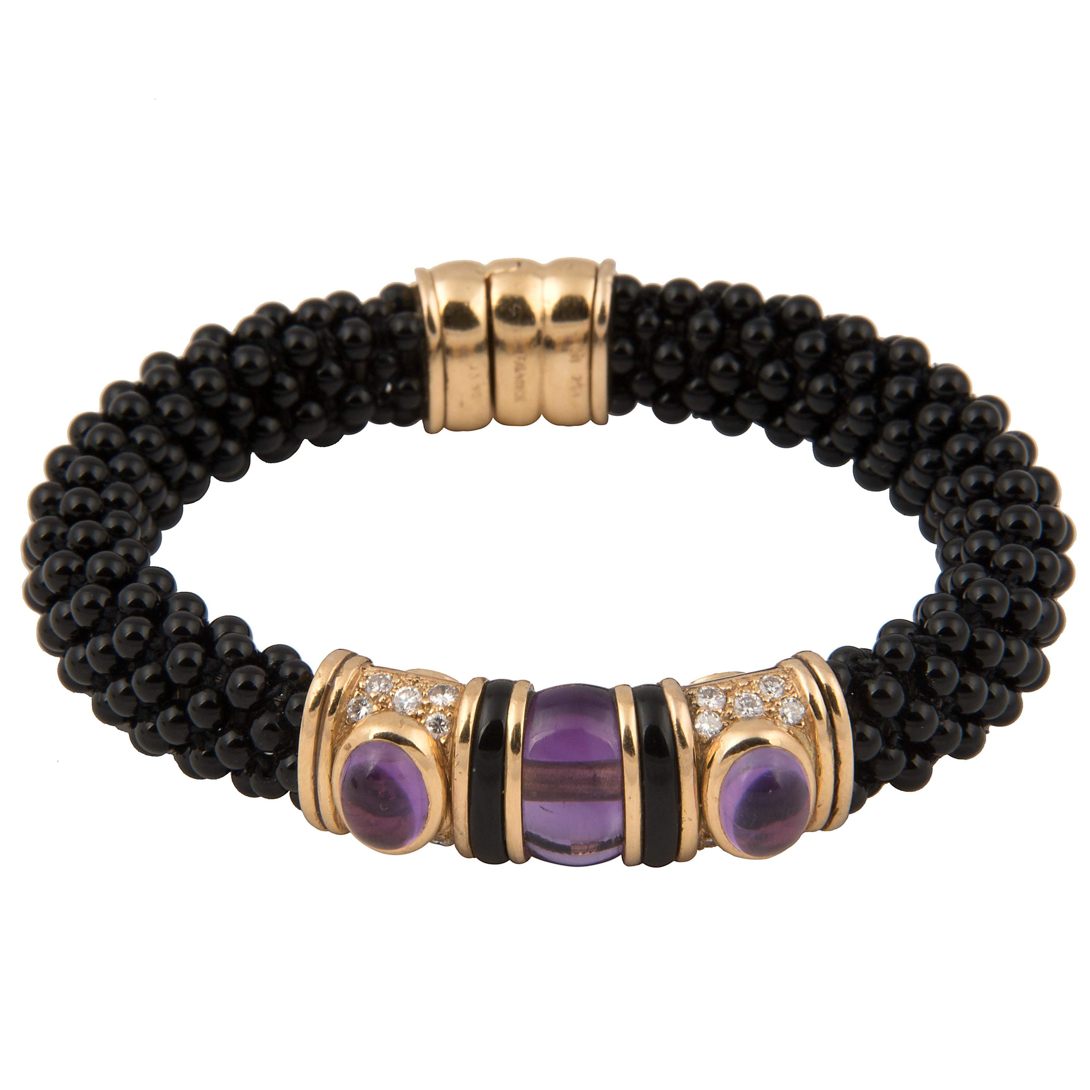 Bangle bracelet designed by Marina B (Bulgari). The band in braided onyx beads on a stainless-steel spring, with an 18k yellow gold motif with onyx, pavé set diamonds and amethyst.
Signed Marina B, Maker's mark, French hallmarks and numbered