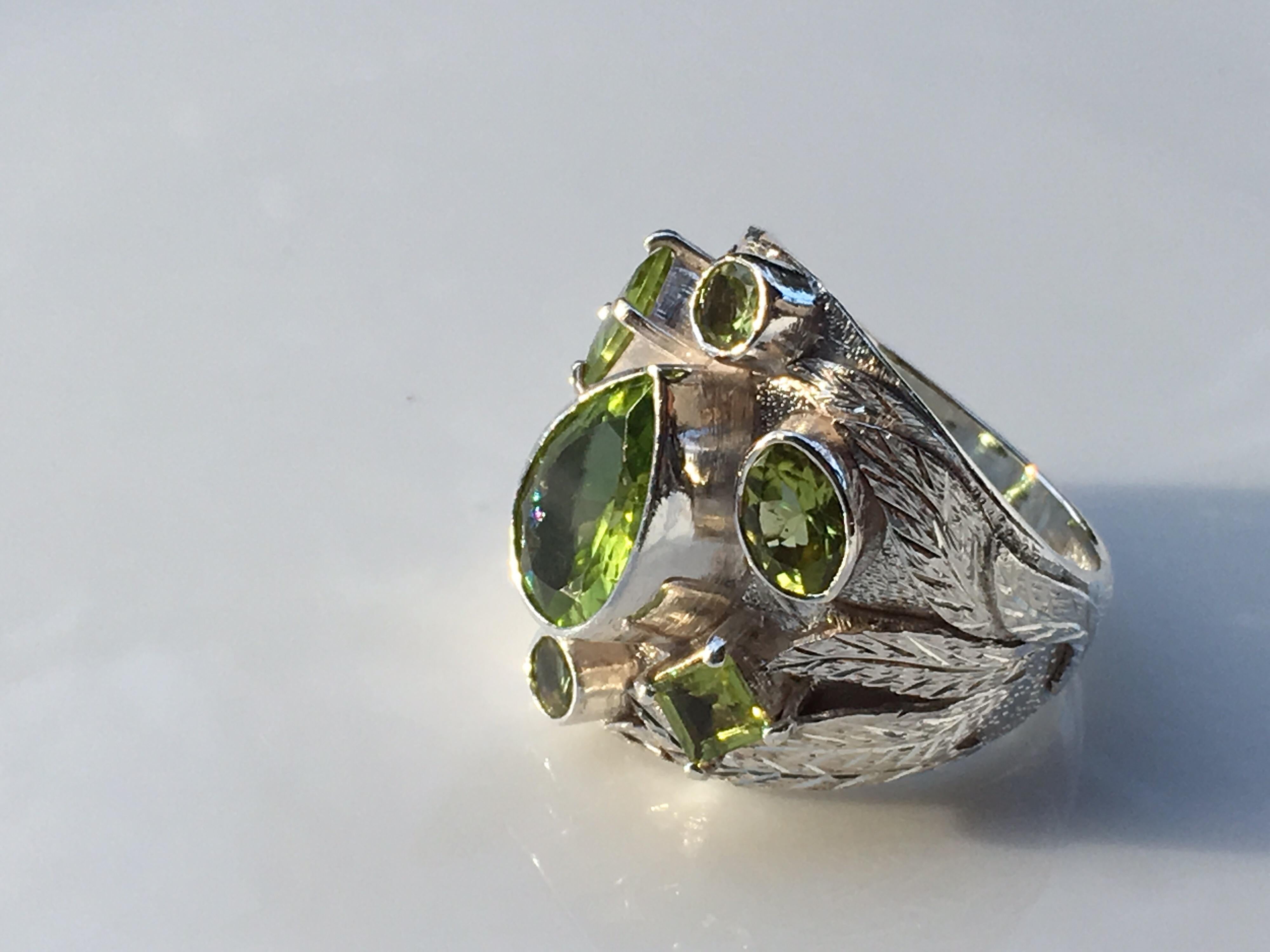 Natural Peridot set in sterling silver is handcrafted one of a kind Ring. seven stones weigh approx 7 Carat.
Size of the ring is 9.5 and the ring can be resized. Total weight of the Ring is 16.03 Gram.
Different shapes used in the rings are Oval