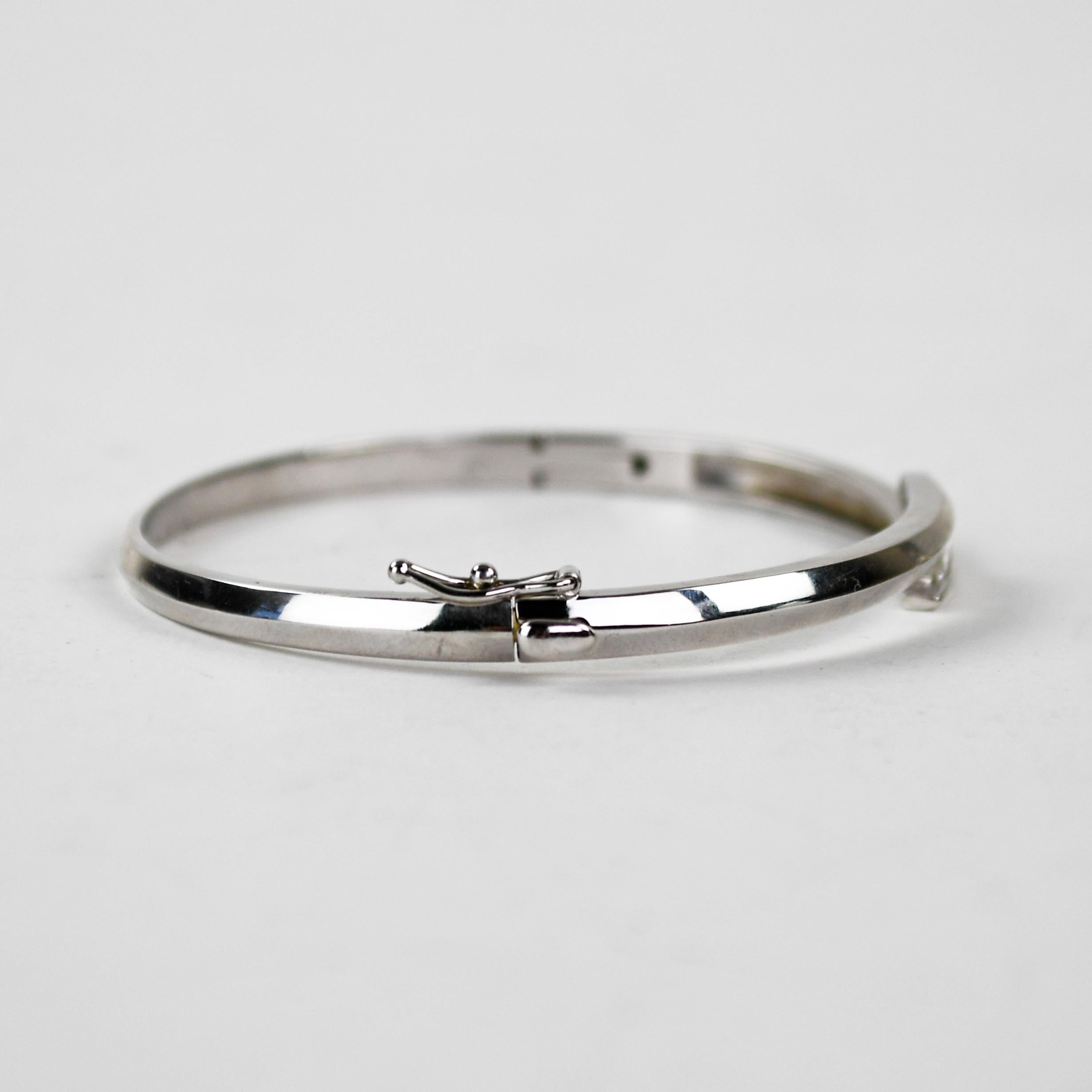 Bracelet bangle en or blanc 14k et diamants.
Estampillé 14k et pèse 15,3 grammes.
Il y a trois diamants de taille princesse, .50 carats au total, couleur I, pureté Vs.
Le bracelet mesure 6,5 mm de large au sommet, et la circonférence intérieure est