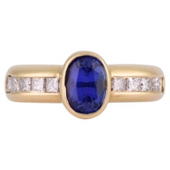 Anillo de oro amarillo de 18 quilates con tanzanita ovalada y diamantes de talla princesa