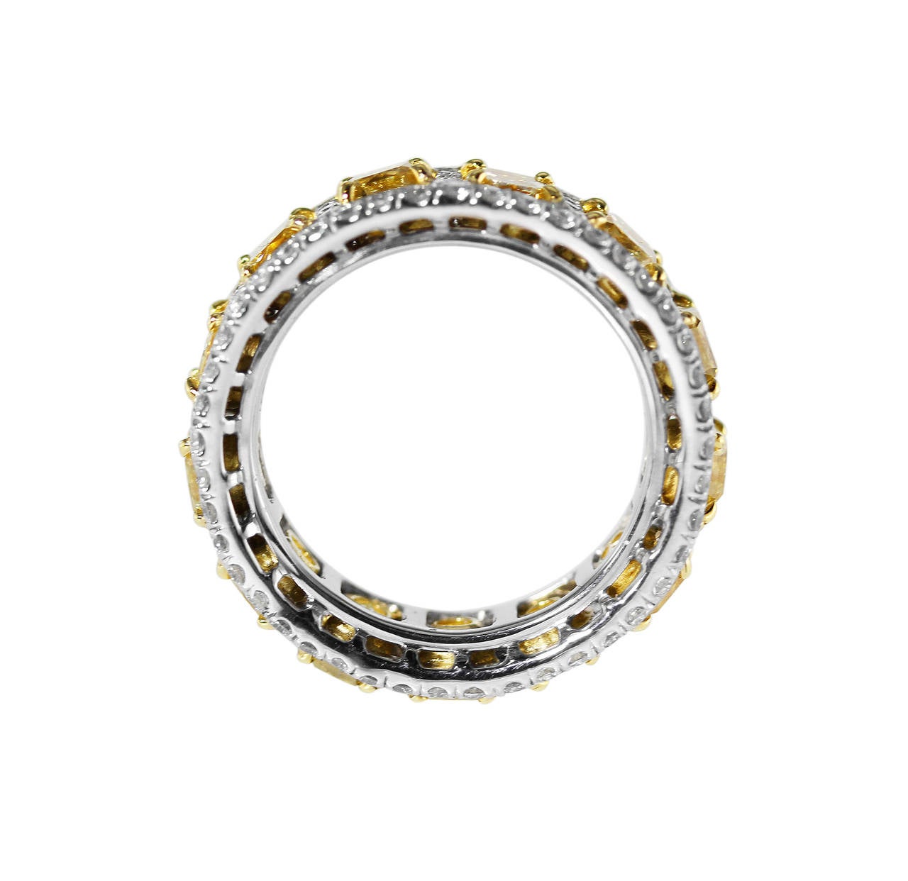 A platinum, 18 karat yellow gold, yellow diamond and near colorless diamond band ring, set throughout with 13 radiant-cut diamonds stated to weigh 7.51 carats of fancy yellow to fancy intense yellow color, accented by 125 small near colorless round