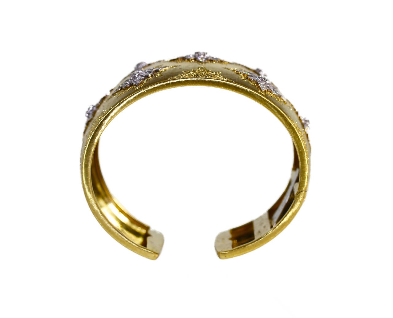 An 18 karat yellow gold and diamond cuff bracelet by Buccellati, Italy, the wide tapered cuff of brushed and engraved gold design set with seven openwork white gold plaques set with 133 round diamonds weighing approximately 3.00 carats, gross weight