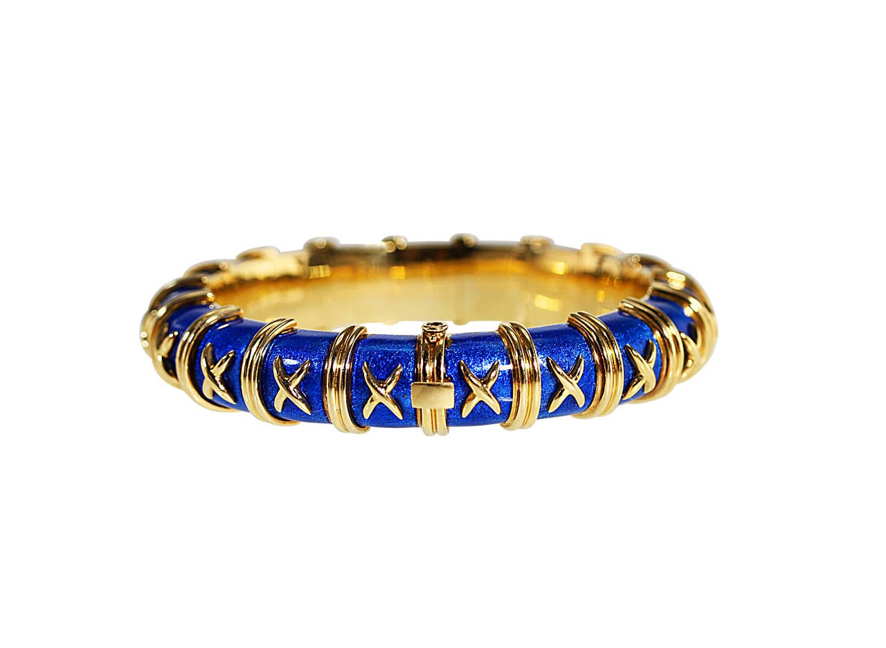 An 18 karat yellow gold and blue paillonne enamel bangle bracelet by Schlumberger for Tiffany & Co., designed as 19 links applied with blue paillonne enamel accented by gold 'x's, gross weight 88.8 grams, length 6 1/2 inches, width 1/2 inch, signed