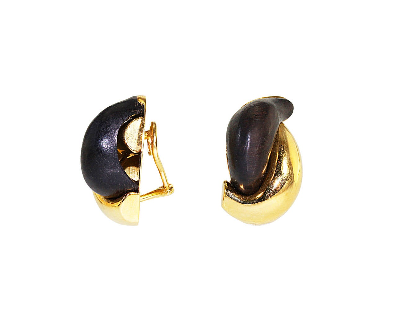 Pair of 18 karat gold and wood earclips by Seaman Schepps, designed as interlocking curves of polished gold and carved wood, gross weight 28.3 grams, measuring 1 1/8 by 7/8 inches, signed Seaman Schepps, with maker's mark, stamped 750.  A great pair