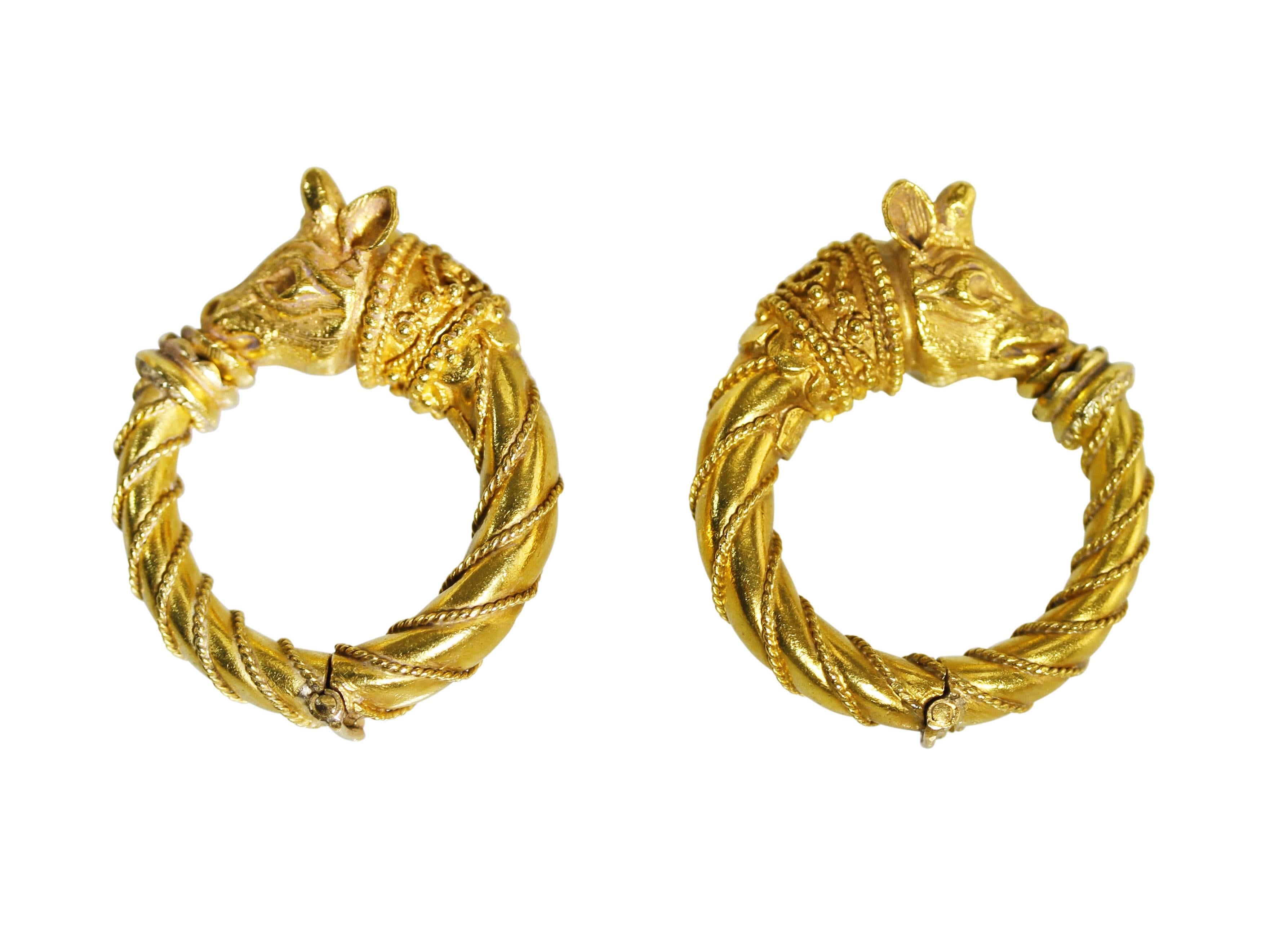 A pair of 22 karat gold hoop earclips by Zolotas, Greece, each hinged hoop with a bull's head motif, measuring 1 1/4 by 3/8 by 1 inch, gross weight 22.9 grams, with makers mark, stamped K22, A57.