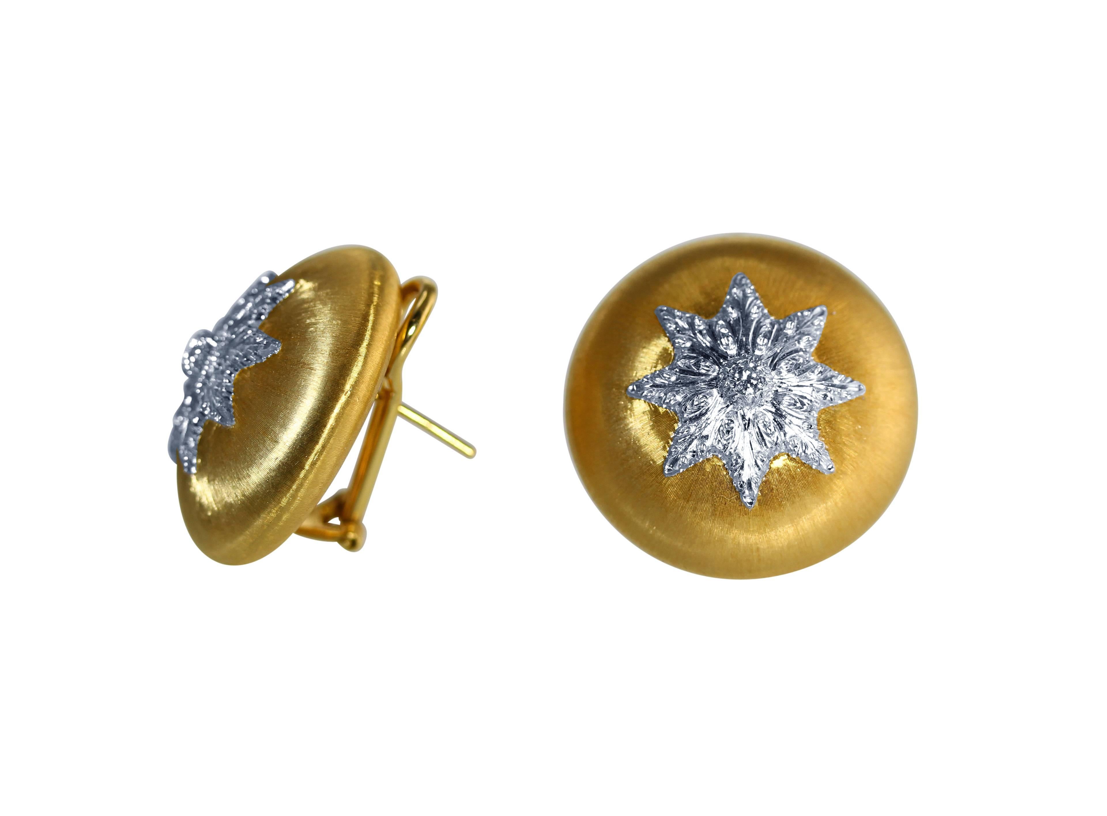 A pair of 18 karat white and yellow gold and diamond earclips by Buccellati, Italy, designed as a bombe buttons centering a white gold motif, accented by 2 round diamonds weighing approximately 0.15 carat, gross weight 23.0 grams, measuring 1 by 1