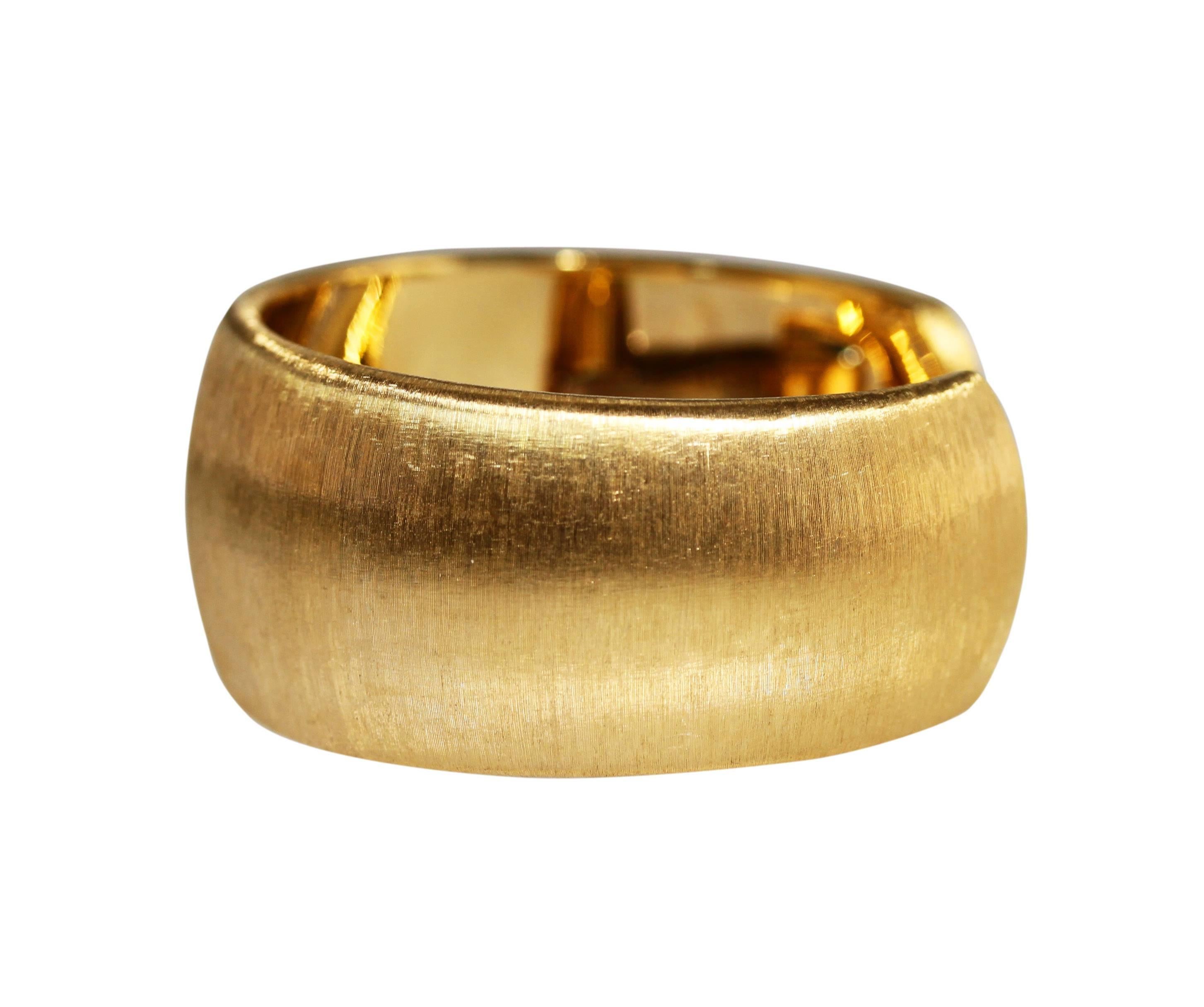 An 18 karat yellow gold cuff bracelet by Buccellati, Italy, the wide cuff of brushed gold appearance with one side hinged, the cuff measuring 6 1/4 inches in circumference and tapering from 1 to 7/8 inch in width, gross weight 54.9 grams, signed