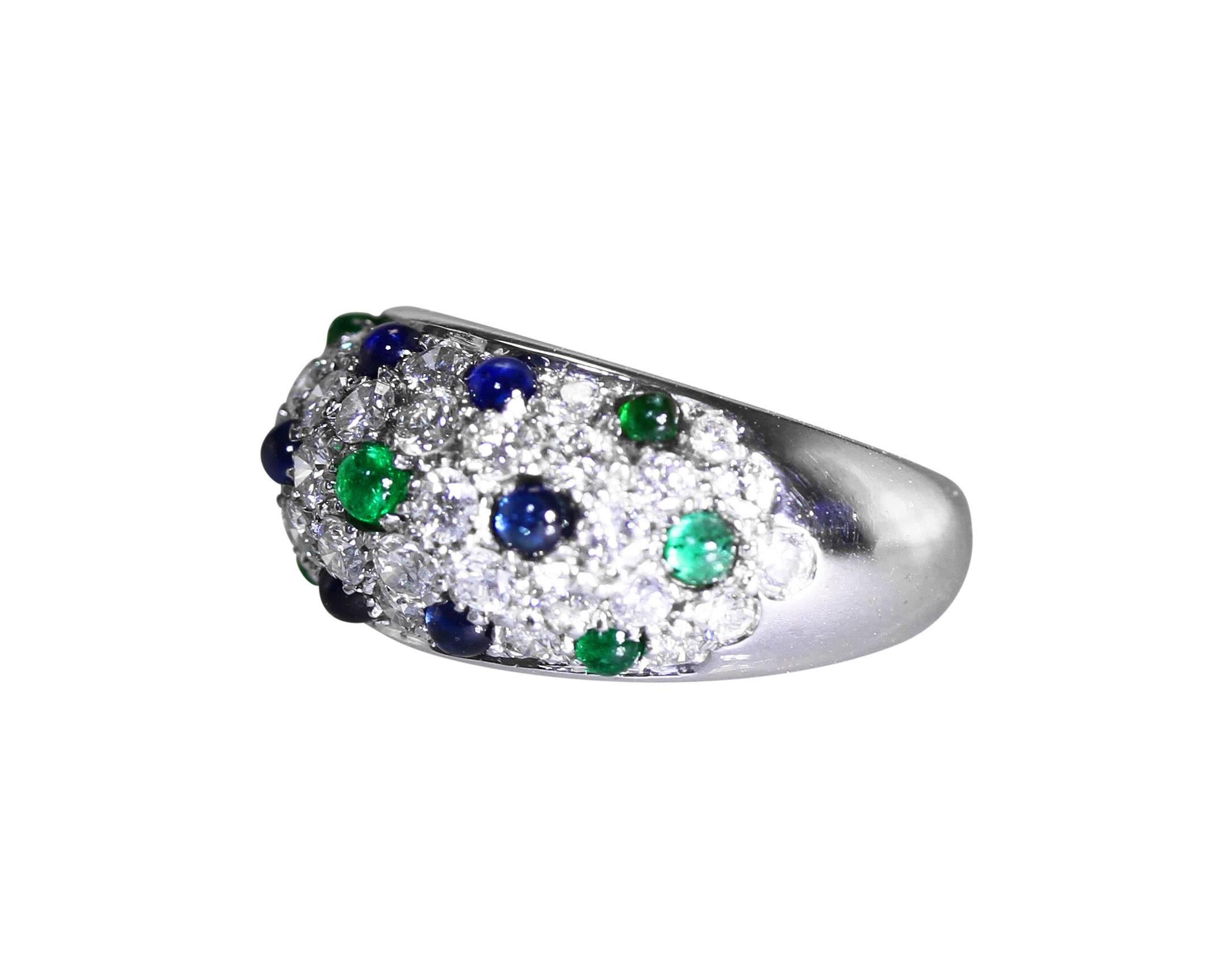 An 18 karat white gold, emerald, sapphire and diamond ring by Cartier, of slightly tapered design pave-set with 36 round diamonds weighing approximately 1.75 carats, accented by 7 cabochon emeralds weighing approximately 0.50 carat, and 6 cabochon