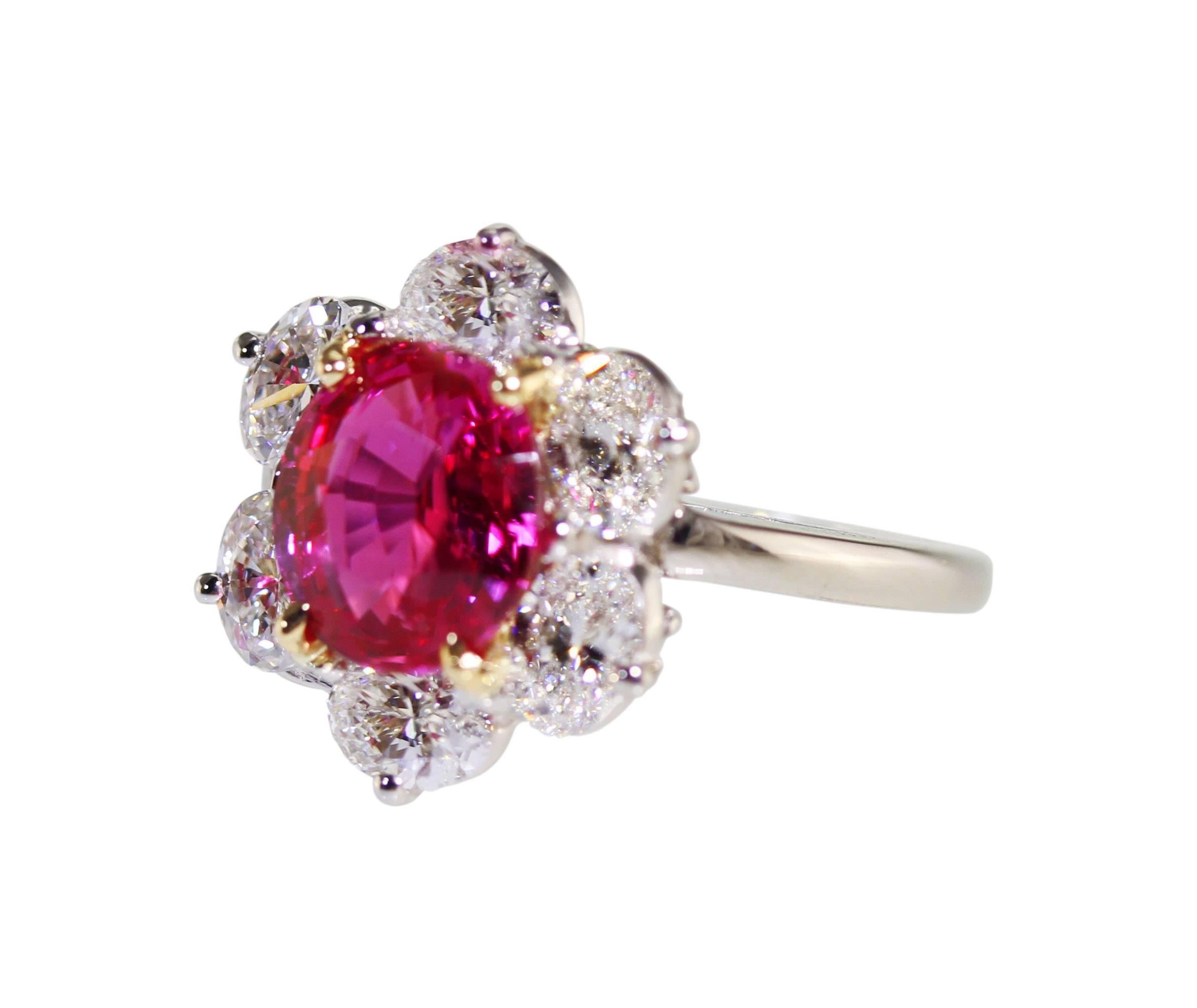 A platinum, 18 karat gold, pink sapphire and diamond ring by Oscar Heyman,  & Brothers, set in the center with an oval pink sapphire weighing 3.31 carats, framed by 6 oval diamonds weighing 1.97 carats, gross weight 6.5 grams, measuring 5/8 by 3/4