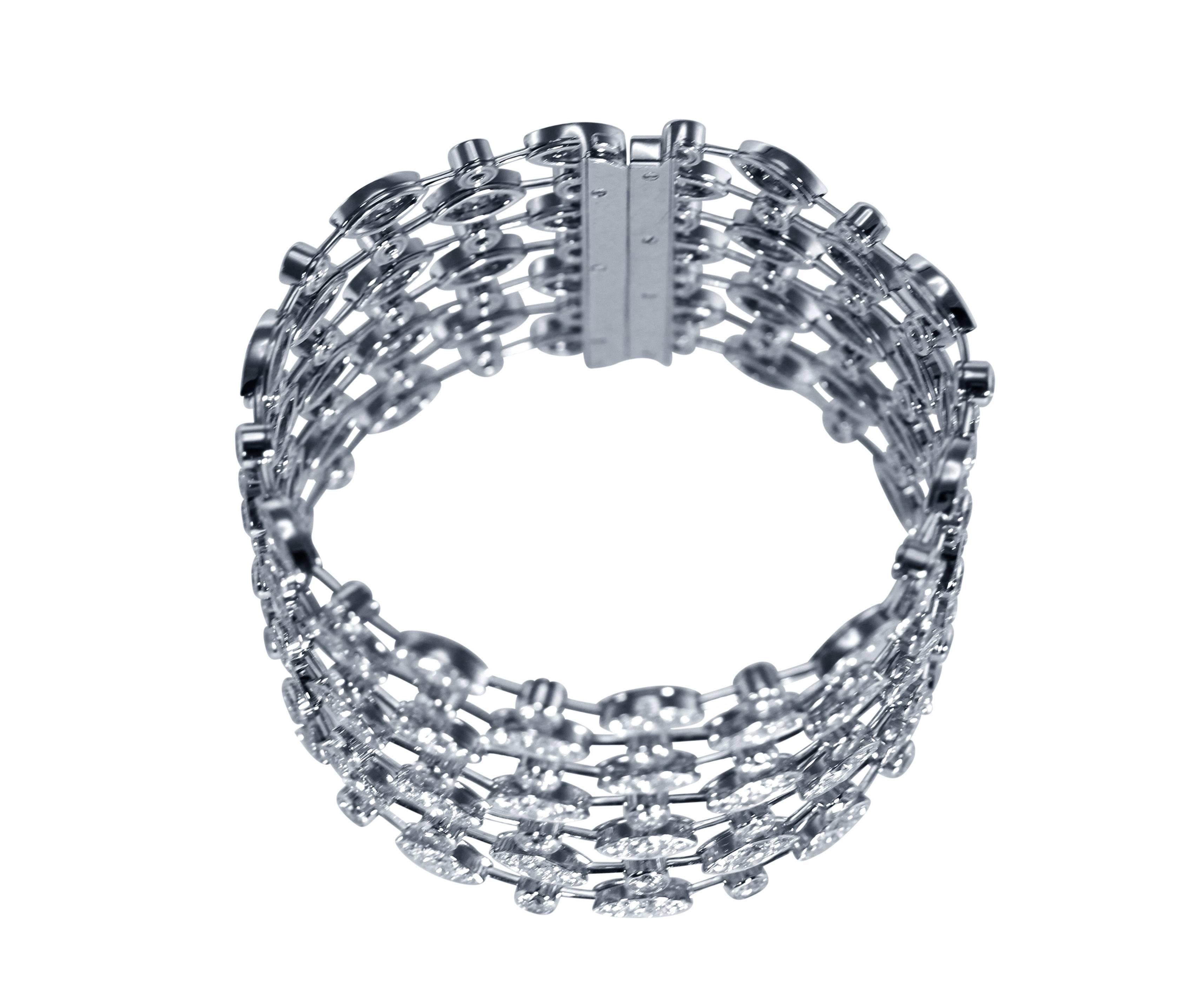 An 18 karat white gold and diamond strap bracelet by Cartier, France, designed as a series of round and lozenge-shaped links connected by knife-edge links, set throughout with 280 round diamonds weighing approximately 30.00 carats, length 7 inches, 