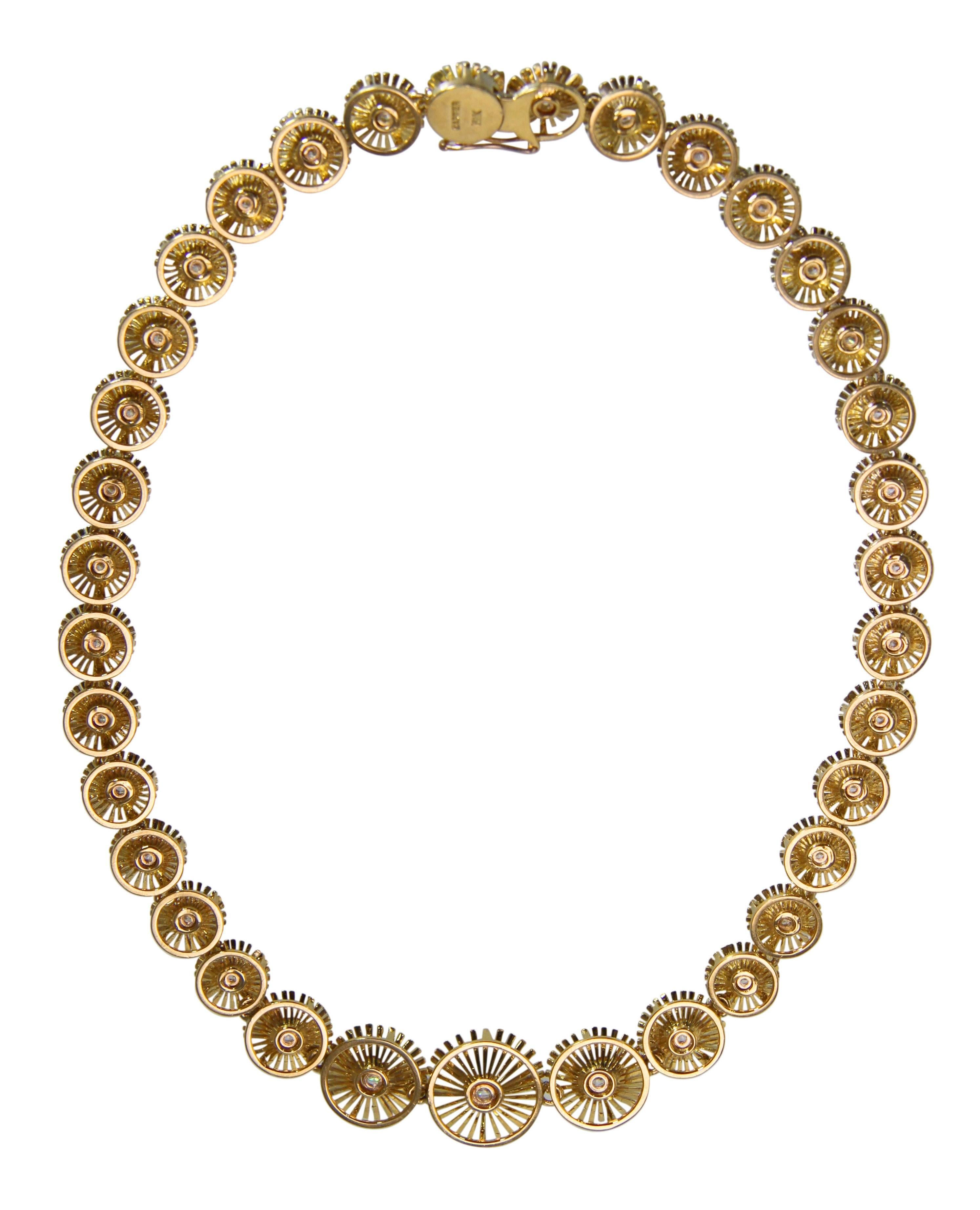 An 18 karat gold and diamond necklace by Cartier, circa 1960,
a graduated strand of circular links designed as openwork flowers set with 35 round diamonds weighing approximately 2.00 carats, length 15 1/4 inches, width tapers from 5/8 to 3/8 inch,