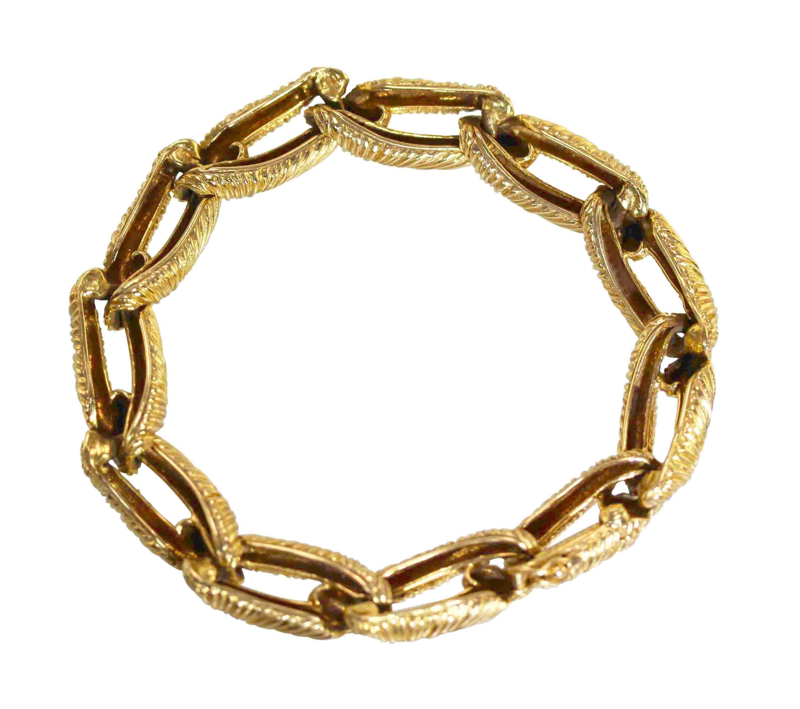 An 18 karat gold link bracelet by Cartier, Paris, circa 1970, composed of eleven textured gold links, measuring 7 1/2 by 3/8 inches, gross weight 47.3 grams, signed Cartier Paris, with French assay and workshop marks.  
