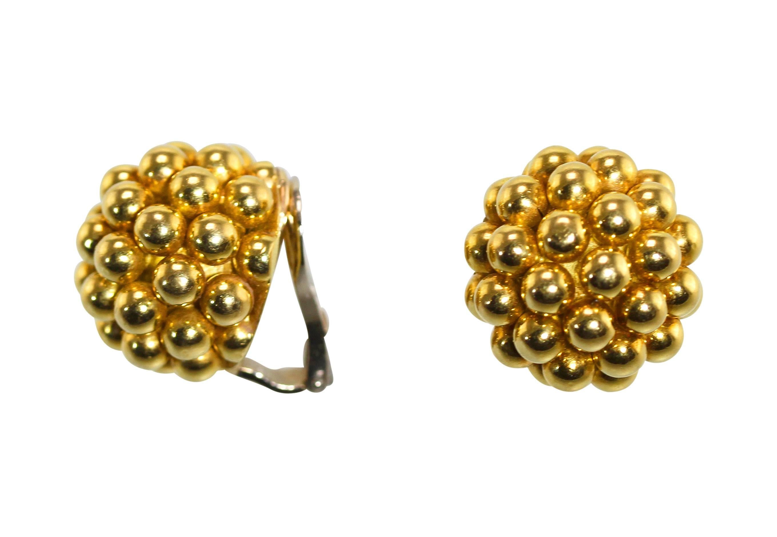 A pair of 18 karat yellow gold earclips by Cartier, Italy, circa 1970, designed as multiple polished gold spheres set together to make a large dome earring, measuring 3/4 by 3/4 inch, gross weight 25.4 grams, signed Cartier, Italy, numbered 55379.