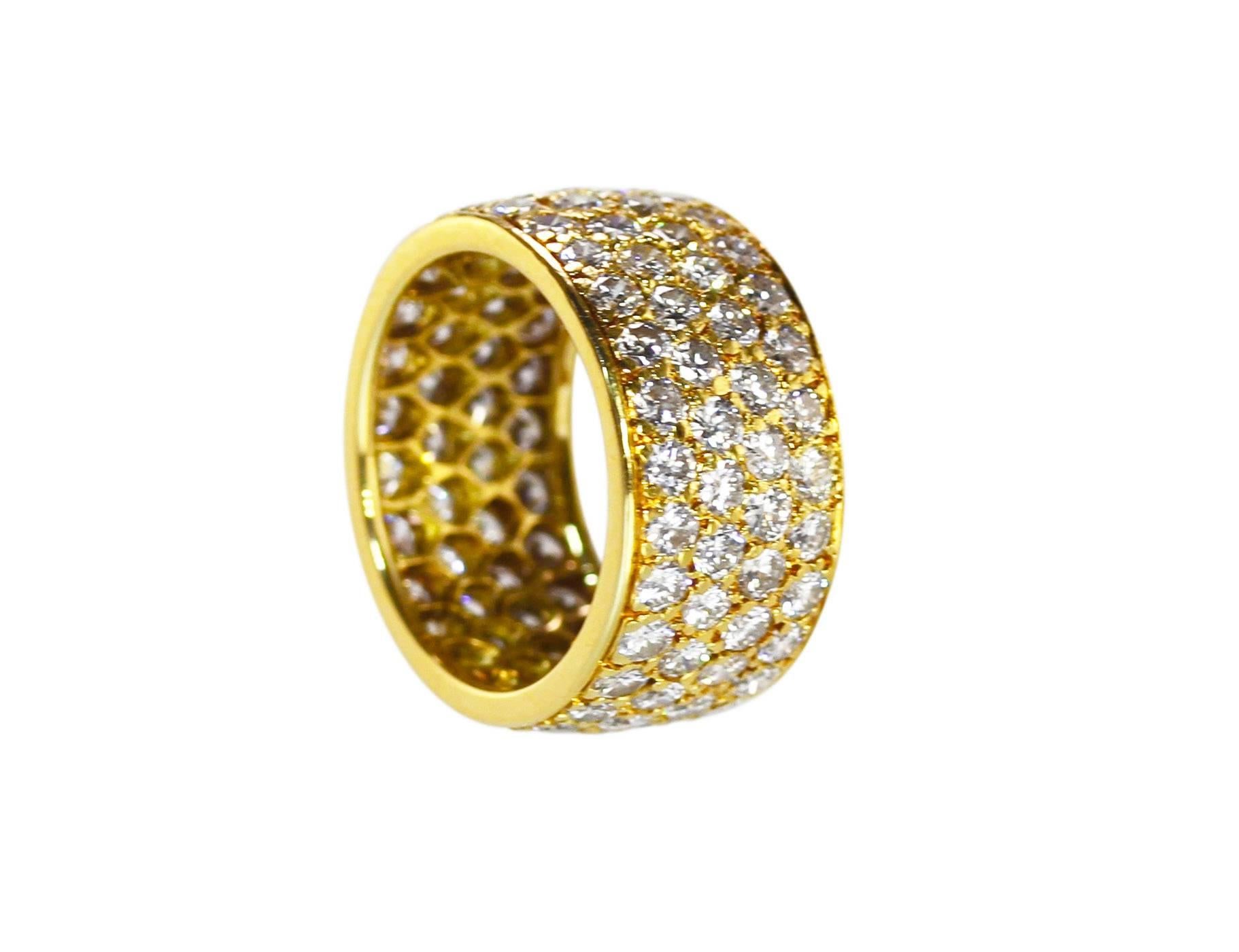 An 18 karat gold and diamond band ring by Van Cleef & Arpels, circa 1970, pavé set with 104 round diamonds designed in 4 rows weighing approximately 4.35 carats, measuring 3/8 by 3/4 by 3/4 inch, size 5 3/4, gross weight 7.2 grams, signed VCA,