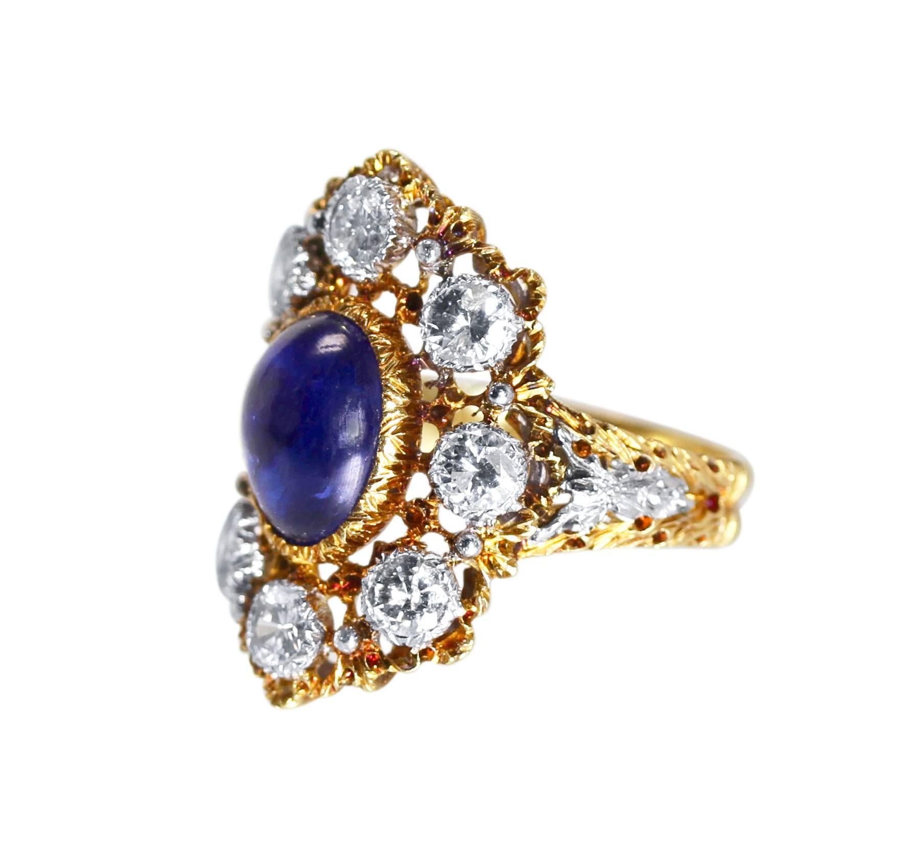An 18 karat white and yellow gold, sapphire and diamond ring by Buccellati, circa 1950, designed as an elongated floral motif centering a cabochon sapphire weighing approximately 5.50 carats, surrounded by 8 round diamonds weighing approximately