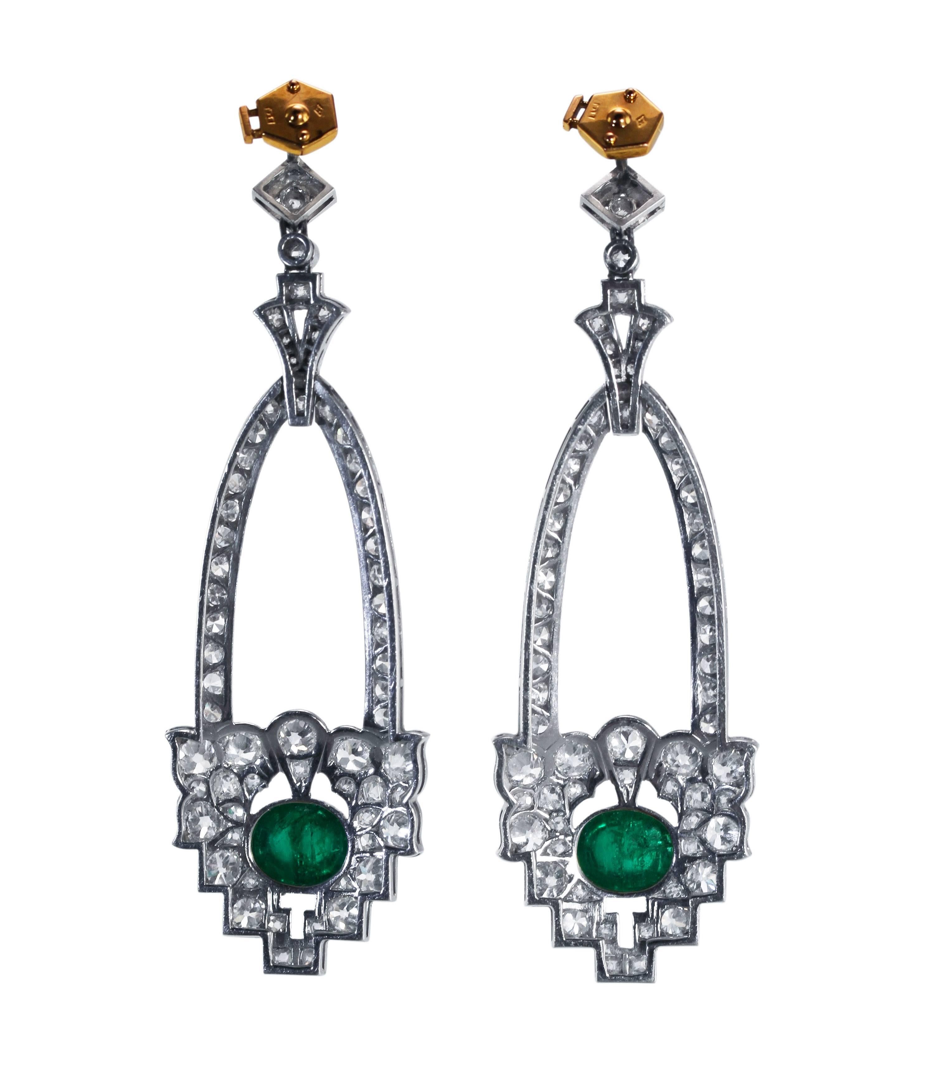 A pair of Art Deco platinum, emerald and diamond earrings, designed as openwork geometric style pendants set at the bottom with 2 cabochon emeralds weighing approximately 4.50 carats, further set with 26 old round diamonds weighing approximately