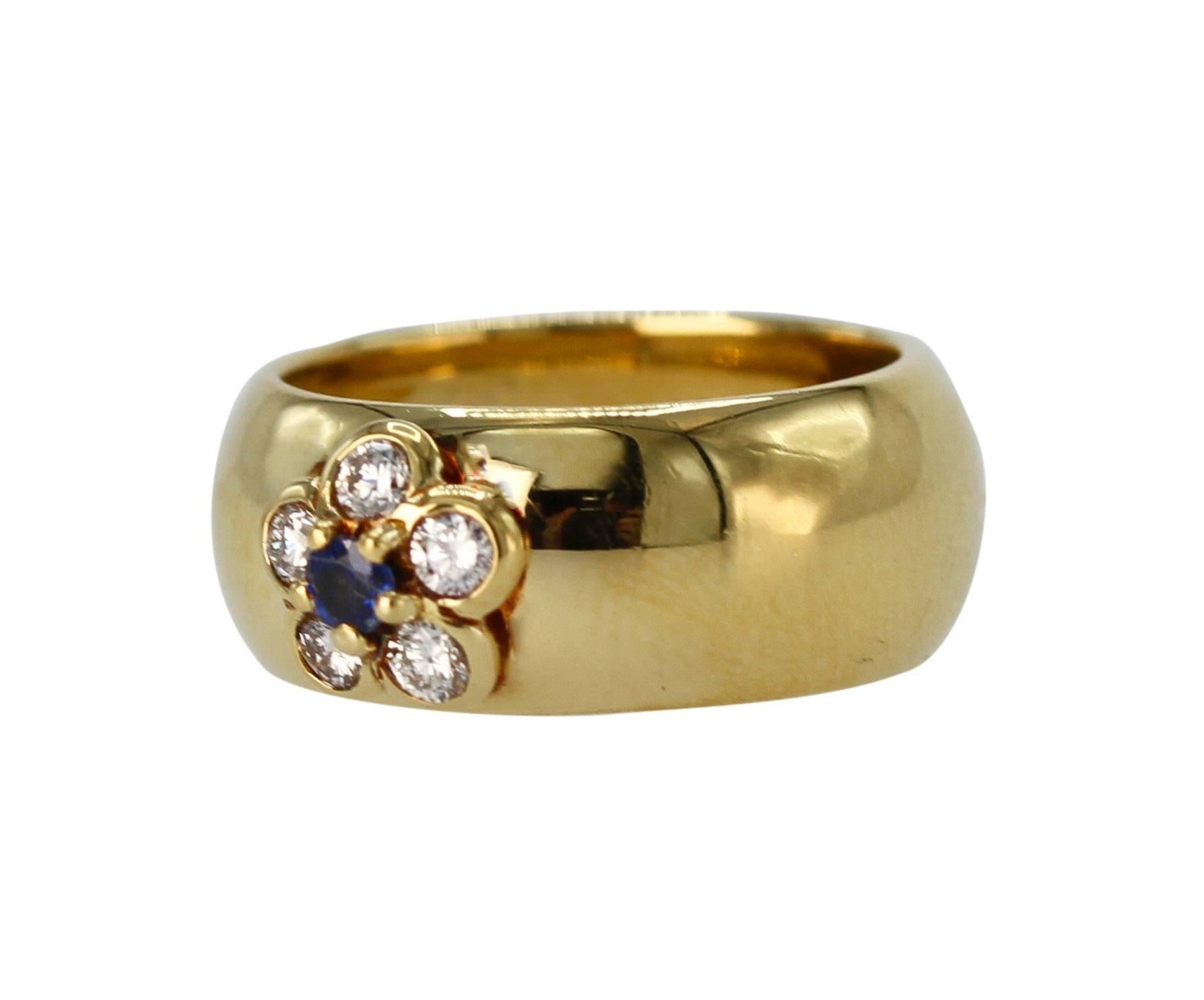An 18 karat yellow gold, sapphire and diamond ring by Van Cleef & Arpels, France, designed as a polished gold band set at the front with a flower motif with a round sapphire weighing approximately 0.10 carat, and 5 round diamonds weighing