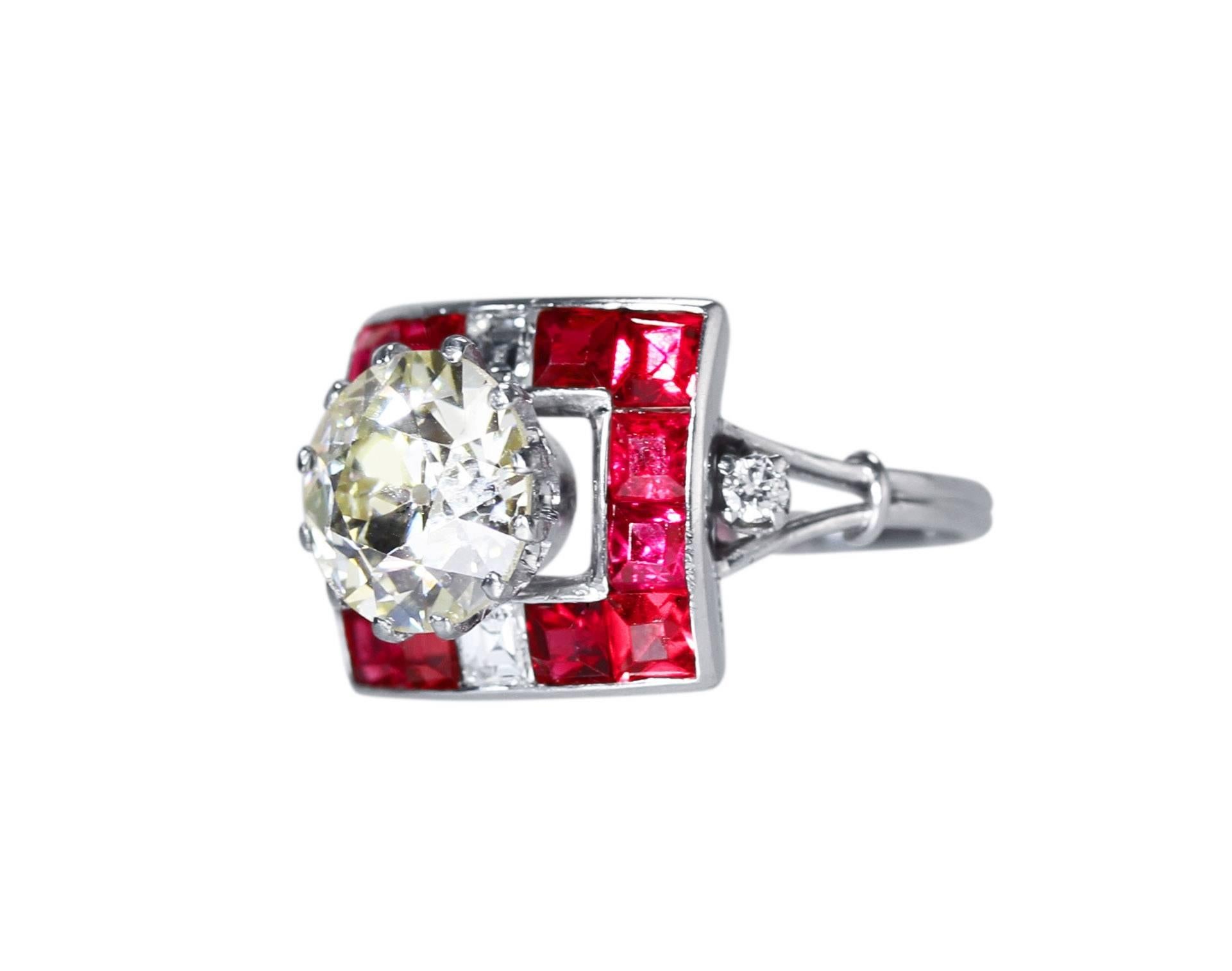 This lovely handmade platinum ring is from the Art Deco period. It has a beautiful look and charm featuring a near 3 carat old European-cut diamond within a square frame accented by 12 old square-cut natural red spinels, 2 asscher-cut  accent