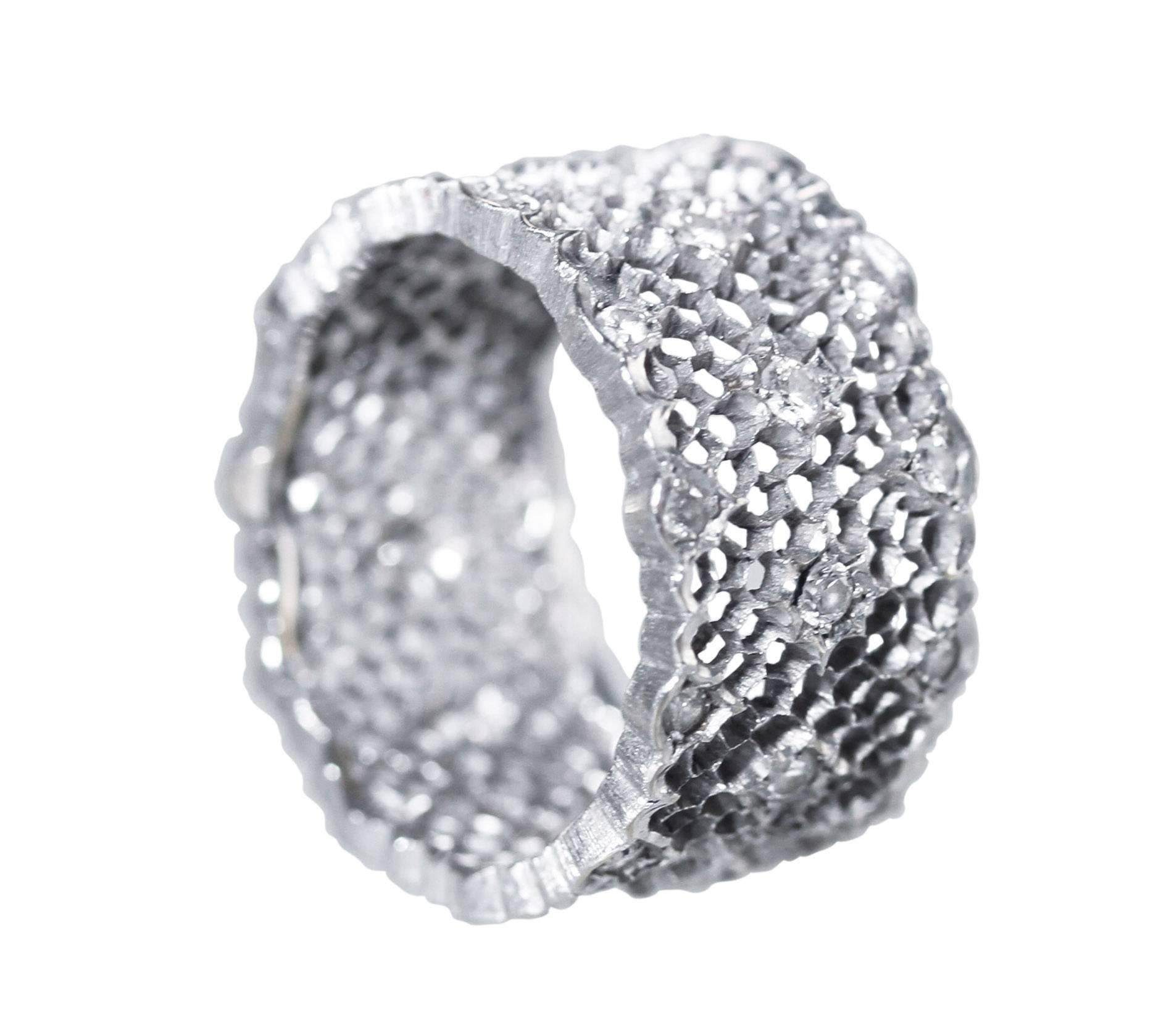 An 18 karat white gold and diamond 'Tulle Broccato' ring by Buccellati, Italy, of openwork design set throughout with 33 round diamonds weighing approximately 0.75 carat, measuring 3/8 by 3/4 by 3/4, finger size 6 1/4, gross weight 5.1 grams, signed