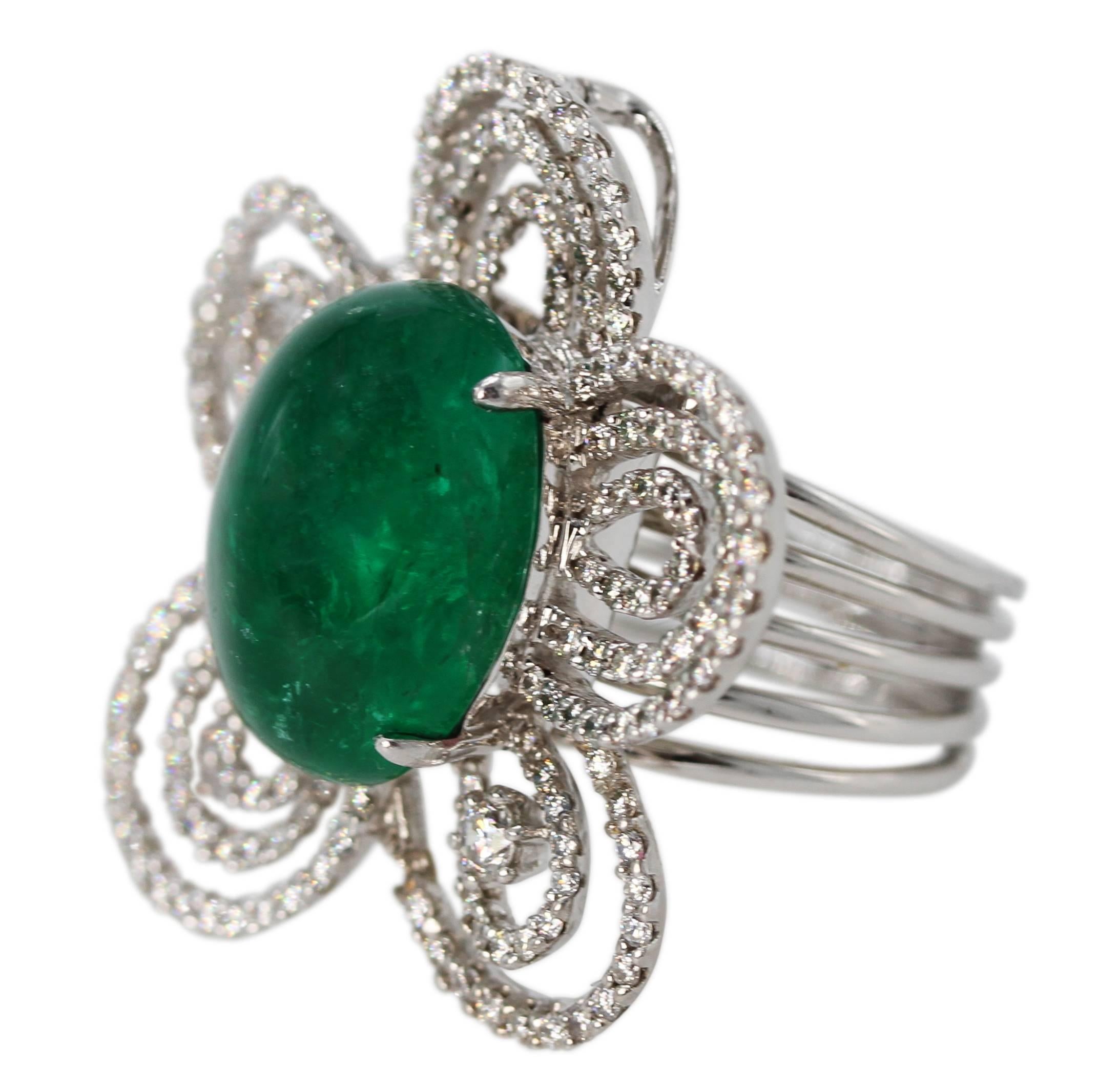 18 Karat White Gold, Emerald and Diamond Convertible Ring/Pendant
• Marked 18k D184 E1451, with makers mark
• Center oval cabochon emerald weighing 14.51 carats
• 186 round diamonds weighing 1.84 carats
• Top measures 1 3/8 by 1 1/4 inches
• Size 7,