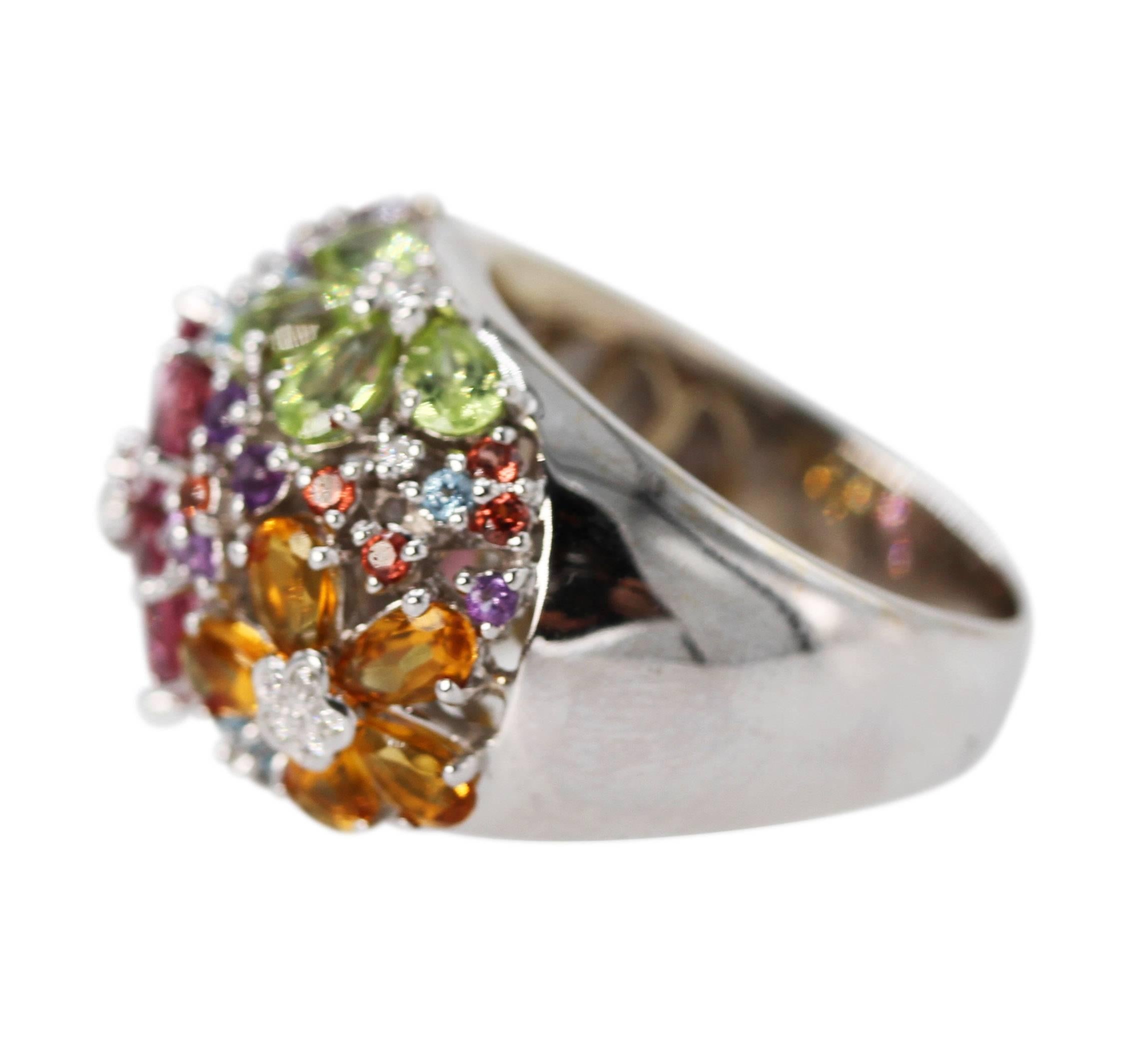 18 Karat White Gold, Multi-Colored Gem and Diamond Ring
• Marked 18k 750 with makers mark
• 5 pear shape-shaped citrines, 5 blue topaz, 5 pink tourmalines, and 4 pear-shaped peridots
• 14 round amethysts, 10 round citrines, 9 round blue topaz
• 26