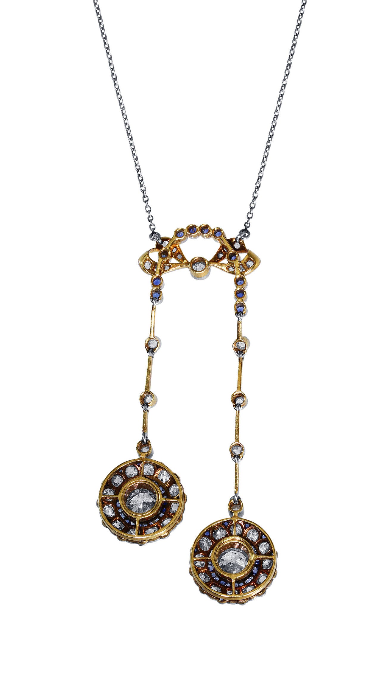 An Edwardian platinum, gold diamond and sapphire lavalière pendant necklace, circa 1910, the delicate pendant of bow design supporting two articulated pendants set with 2 old European-cut diamonds weighing approximately 2.00 carats, framed by 43