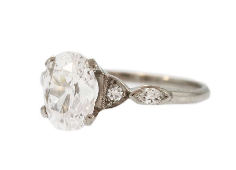 Set in the center with an old cut oval diamond weighing 1.63 carats, flanked by 2 single-cut and 2 marquise-shaped diamonds weighing approximately 0.10 carat, mounted in platinum, size 5 1/2, gross weight 3.2 grams, measuring 7/8 by 3/4