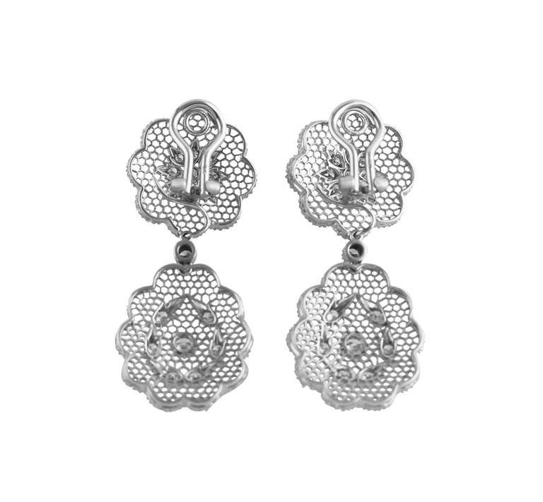 A stunning pair of 18 karat white gold and diamond day-and-night earclips by Buccellati, designed as four openwork honeycomb plaques set throughout with 34 round diamonds weighing approximately 1.60 carats, gross weight 17.3 grams, measuring 1 7/8