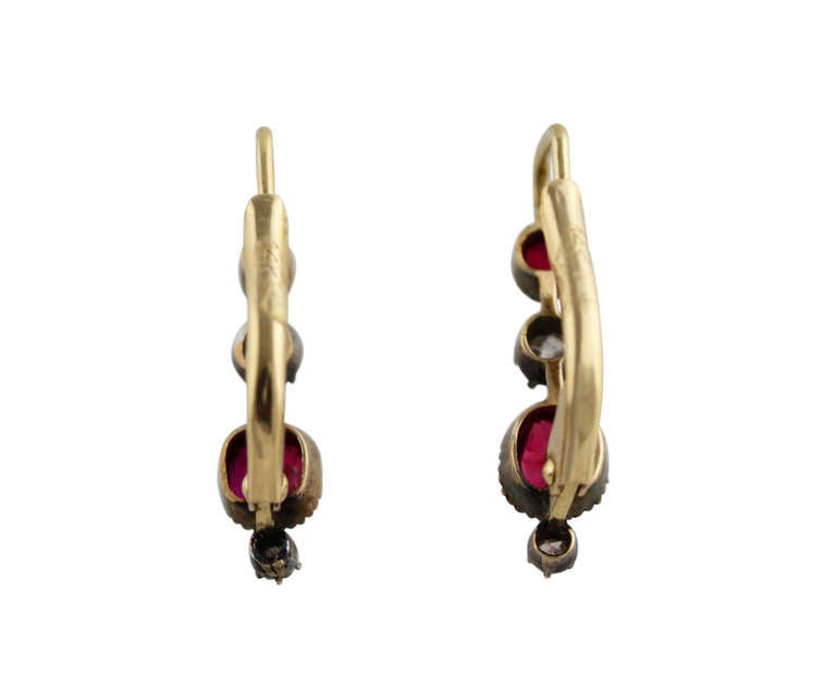 An elegant pair of silver-topped gold, ruby and diamond earrings, set with 4 cushion-shaped clear and bright red rubies weighing approximately 1.75 carats, and 4 old mine-cut diamonds weighing approximately 0.15 carat, gross weight 2.8 grams,