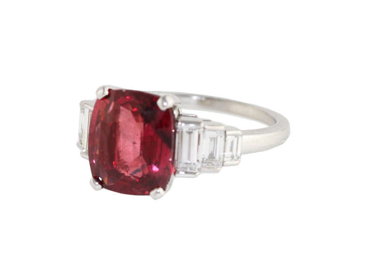 A beautiful platinum, ruby and diamond ring by Bulgari, set in the center with a cushion-shaped ruby weighing 4.62 carats, flanked by 6 baguette diamonds weighing approximately 0.75 carat, gross weight 6.7 grams, size 6 1/2, measuring 3/4 by 1/2