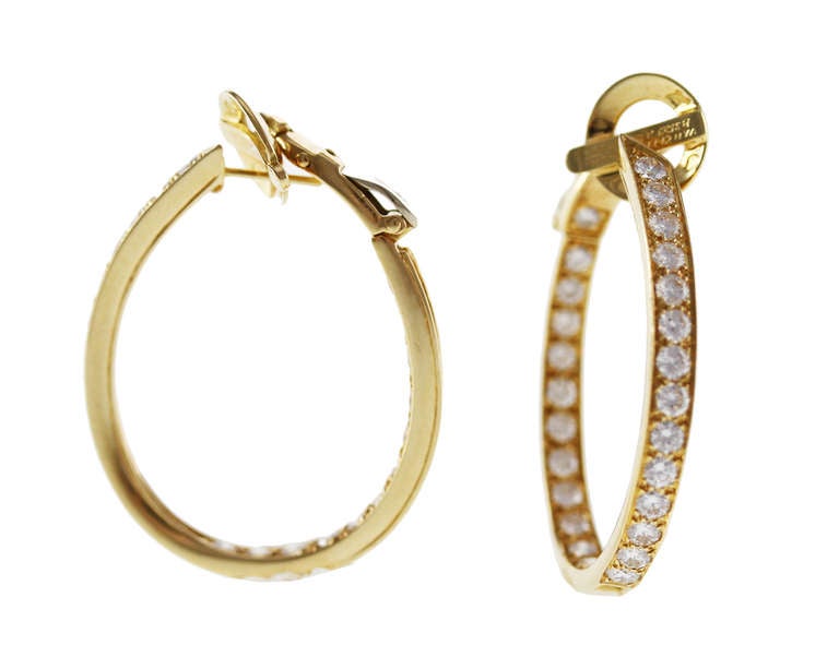 A lovely pair of 18 karat yellow gold and diamond hoop earclips by Van Cleef & Arpels, designed as oblong hoops set with 56 round diamonds weighing approximately 4.00 carats, gross weight 15.3 grams, measuring 1 1/4 by 1/8 by 1 1/8 inches,