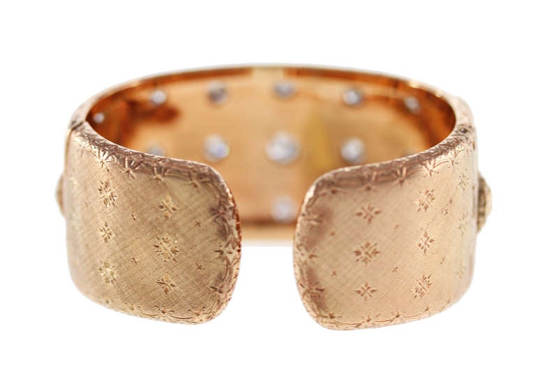 This unique 18 karat rose gold and diamond cuff bracelet was made by Buccellati, Italy, of slightly tapered design collet-set with 23 round diamonds weighing approximately 5.00 carats, with ornate gold texturing, gross weight 65.3 grams, length 6