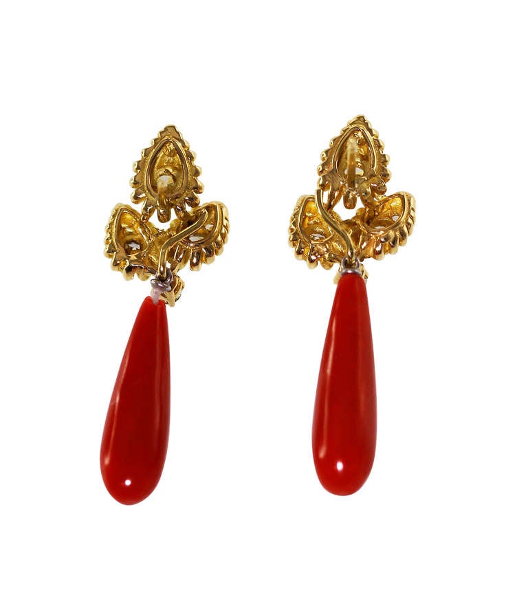 A pair of 18 karat yellow gold and diamond Day/Night earrings with detachable pendant coral drops, the tops of triple leaf form with gold rope borders, set with 14 round diamonds weighing approximately 1.10 carats, supporting detachable coral drops,