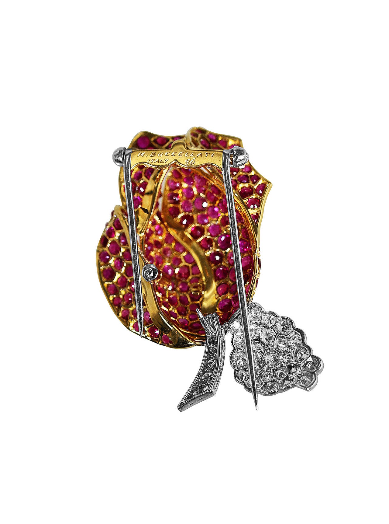 An 18 karat white and yellow gold, ruby and diamond rose brooch by Buccellati, Italy, the stylized rose set with 160 round rubies weighing approximately 8.00 carats, the stem and leaf set with 35 round diamonds weighing approximately 1.25 carats,