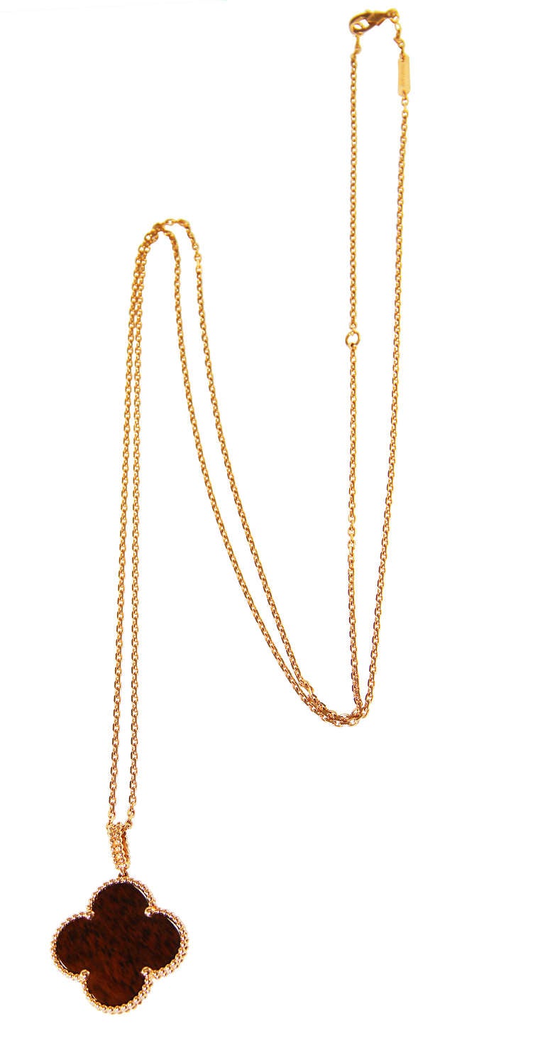 An 18 karat rose gold and Bois d'Amourette wood Alhambra necklace by Van Cleef and Arpels, the pendant composed of a carved wood section within a rose gold frame, completed by a rose gold link necklace, gross weight 14.4 grams, length of necklace 36