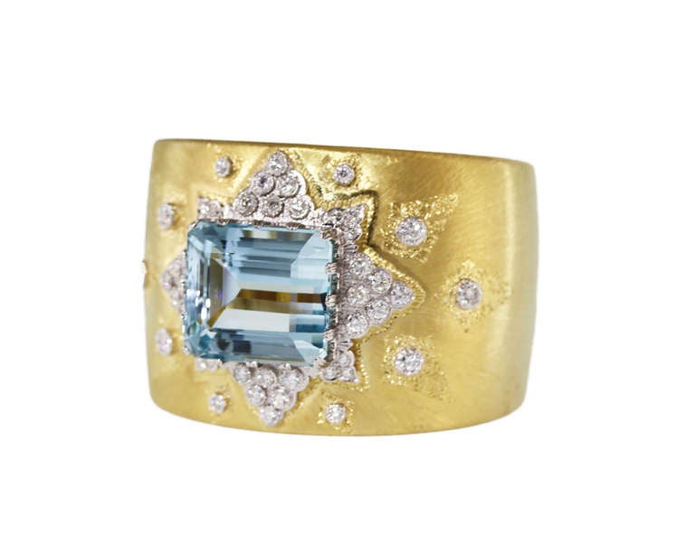 An 18 karat yellow and white gold, aquamarine and diamond cuff bracelet by Buccellati, of slightly tapered design set in the center with an emerald-cut aquamarine weighing approximately 50.00 carats, accented by 46 round diamonds weighing