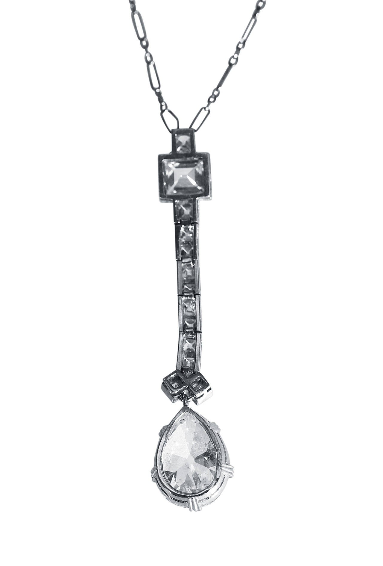 An Art Deco platinum and diamond pendant necklace, circa 1925, the articulated pendant set with an old pear-shaped diamond 2.70 carats, surmounted by 12 French-cut, 1 round and 1 step-cut diamond weighing approximately 1.30 carats, completed by a