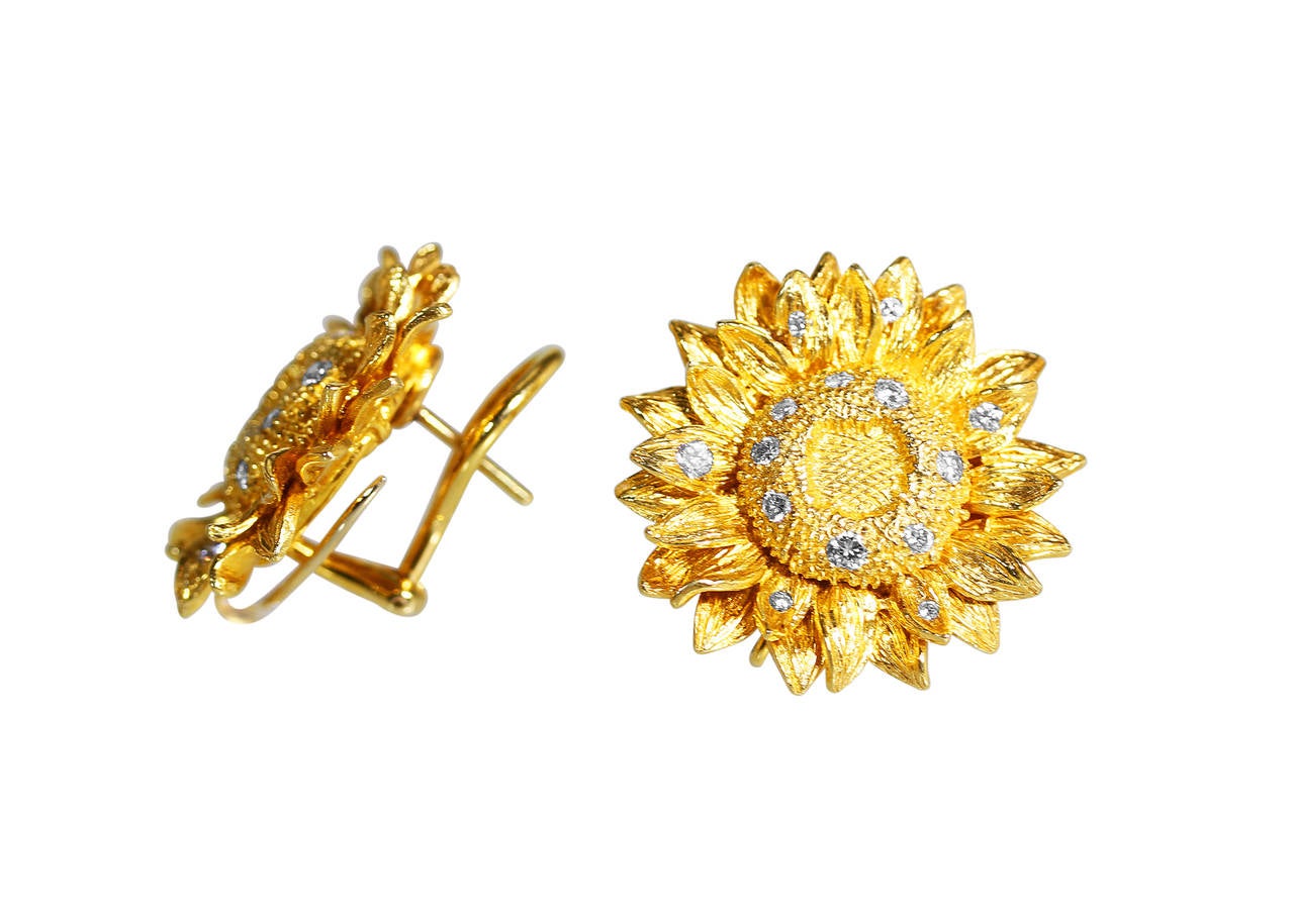 A pair of 18 karat yellow gold and diamond sunflower earclips by Asprey, designed as sunflower heads of textured gold accented by 28 round diamonds weighing approximately 0.50 carat, gross weight 21.0 grams, measuring 1 by 1 inch, signed Asprey.