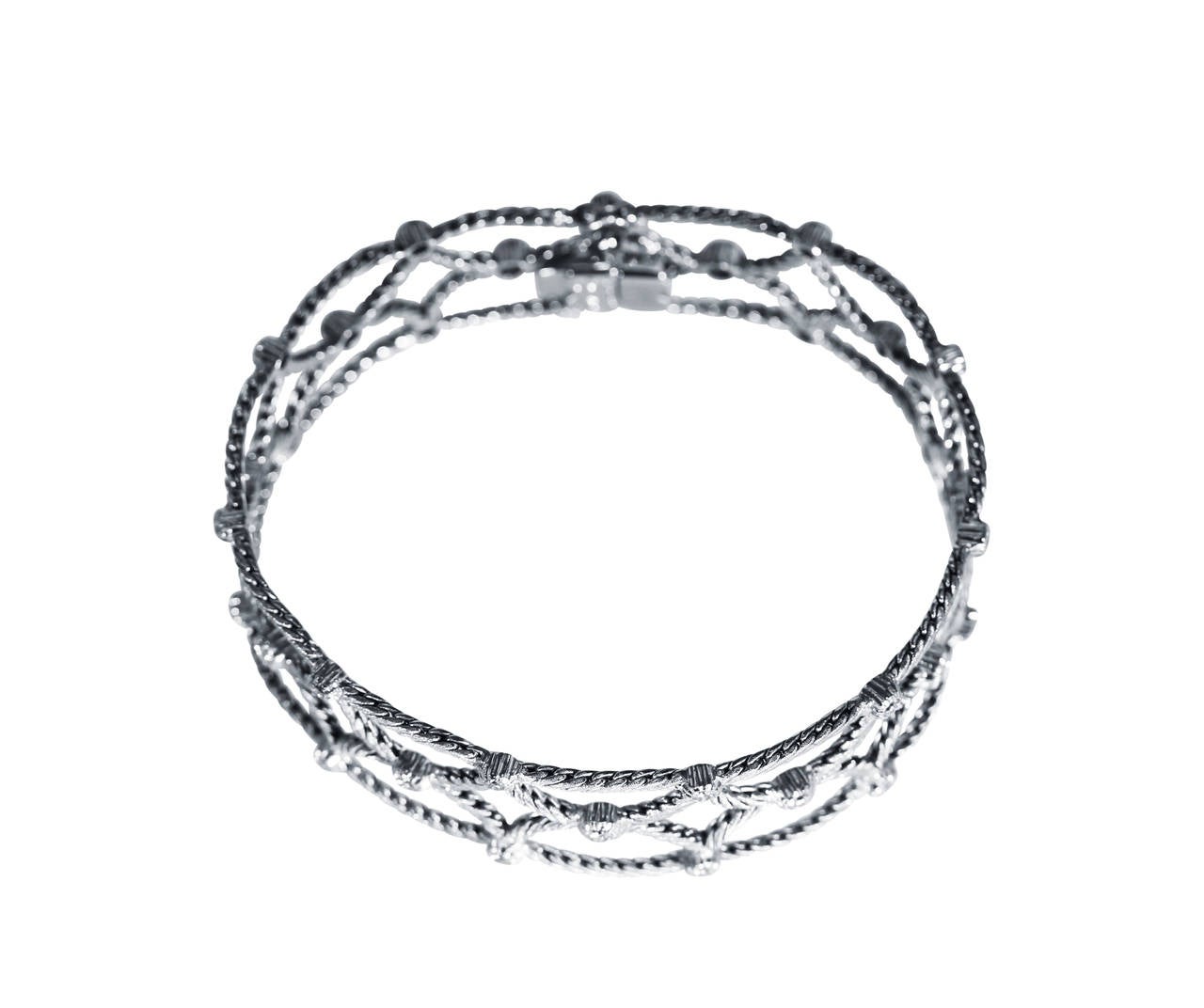 An 18 karat white gold and diamond bracelet by Buccellati, Italy, of lattice and swag design composed of white gold rope twist links accented by 33 round diamonds weighing approximately 1.50 carats, gross weight 25.6 grams, length 7 inches, width