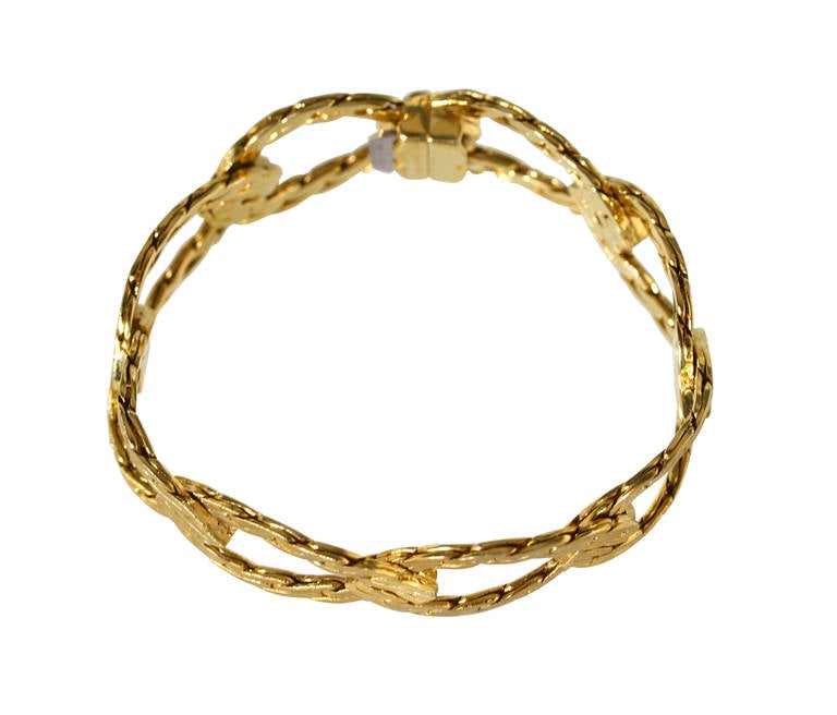 An 18 karat yellow gold bracelet by Buccellati, Italy, design as two interlocking bands of textured gold, gross weight 56.7 grams, length 7 5/8 inches, width 3/4 inch, signed Buccellati, Italy.  This bracelet is beautifully made and features the