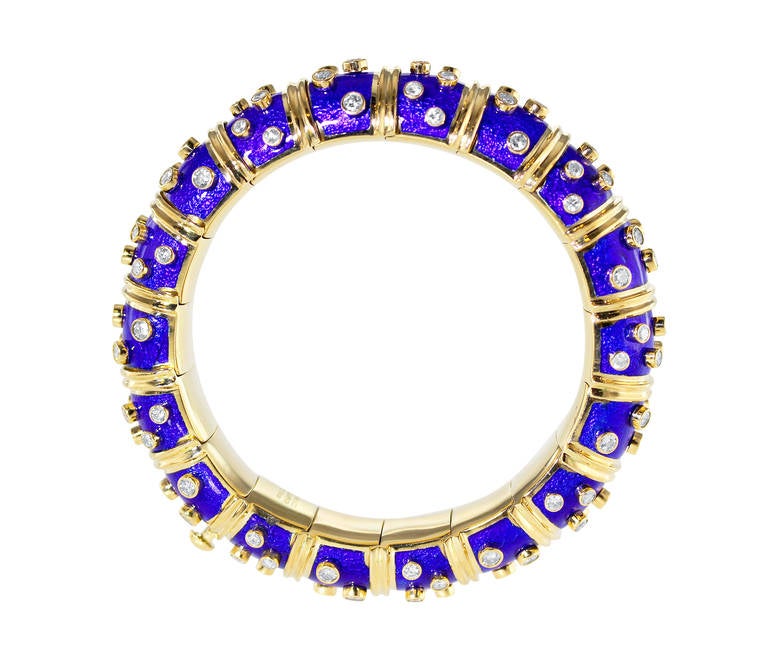 An 18 karat yellow gold, diamond and cobalt blue enamel bangle bracelet by Schlumberger for Tiffany & Co., composed of 18 bombe links applied with paillonne cobalt blue colored enamel, accented by round diamonds weighing approximately 8.00 carats,
