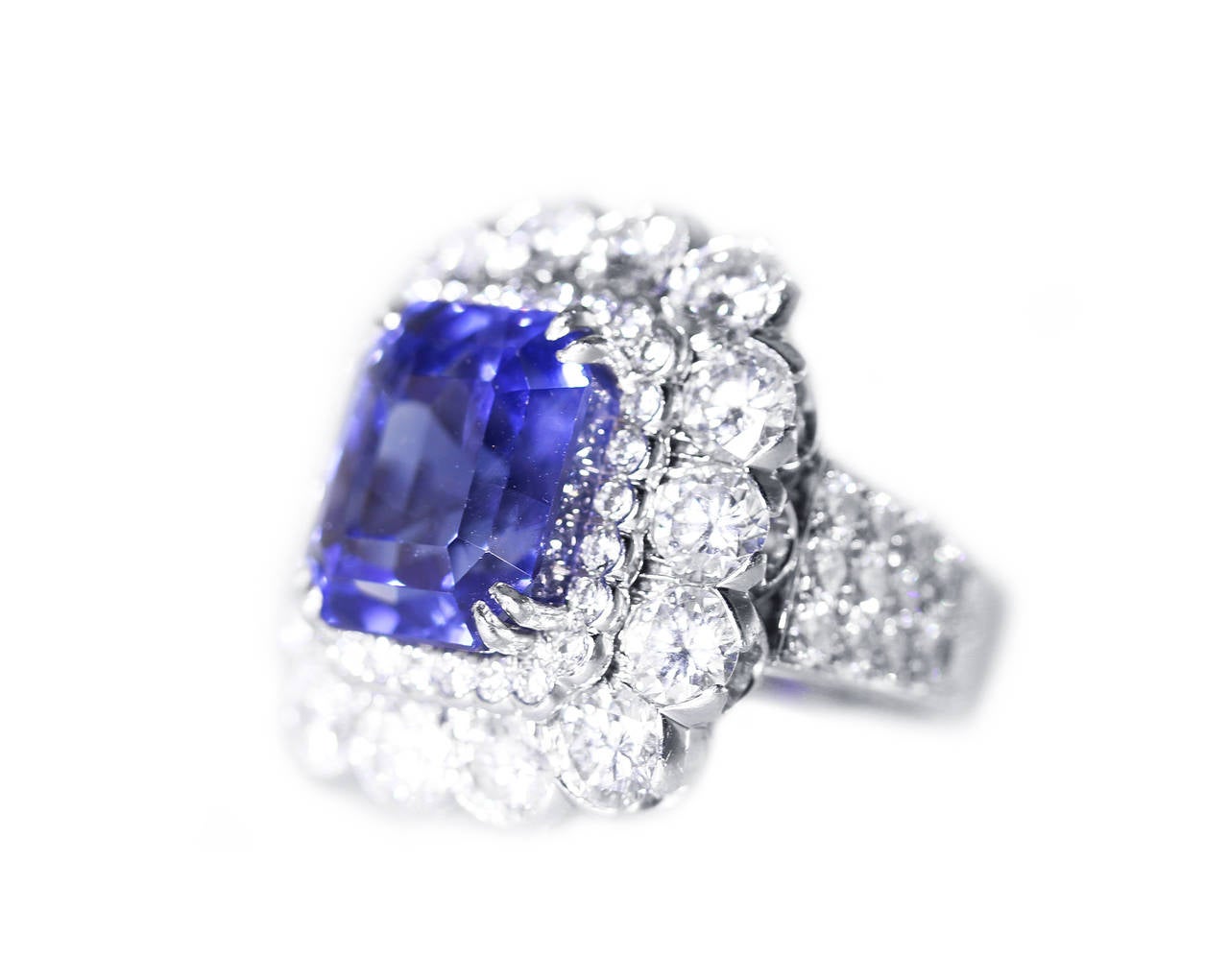 A stunning platinum, sapphire and diamond ring by David Webb, set in the center with an emerald-cut sapphire weighing 19.47 carats, framed and flanked by 54 round diamonds weighing approximately 7.00 carats, gross weight 25.2 grams, size 6 1/4,
